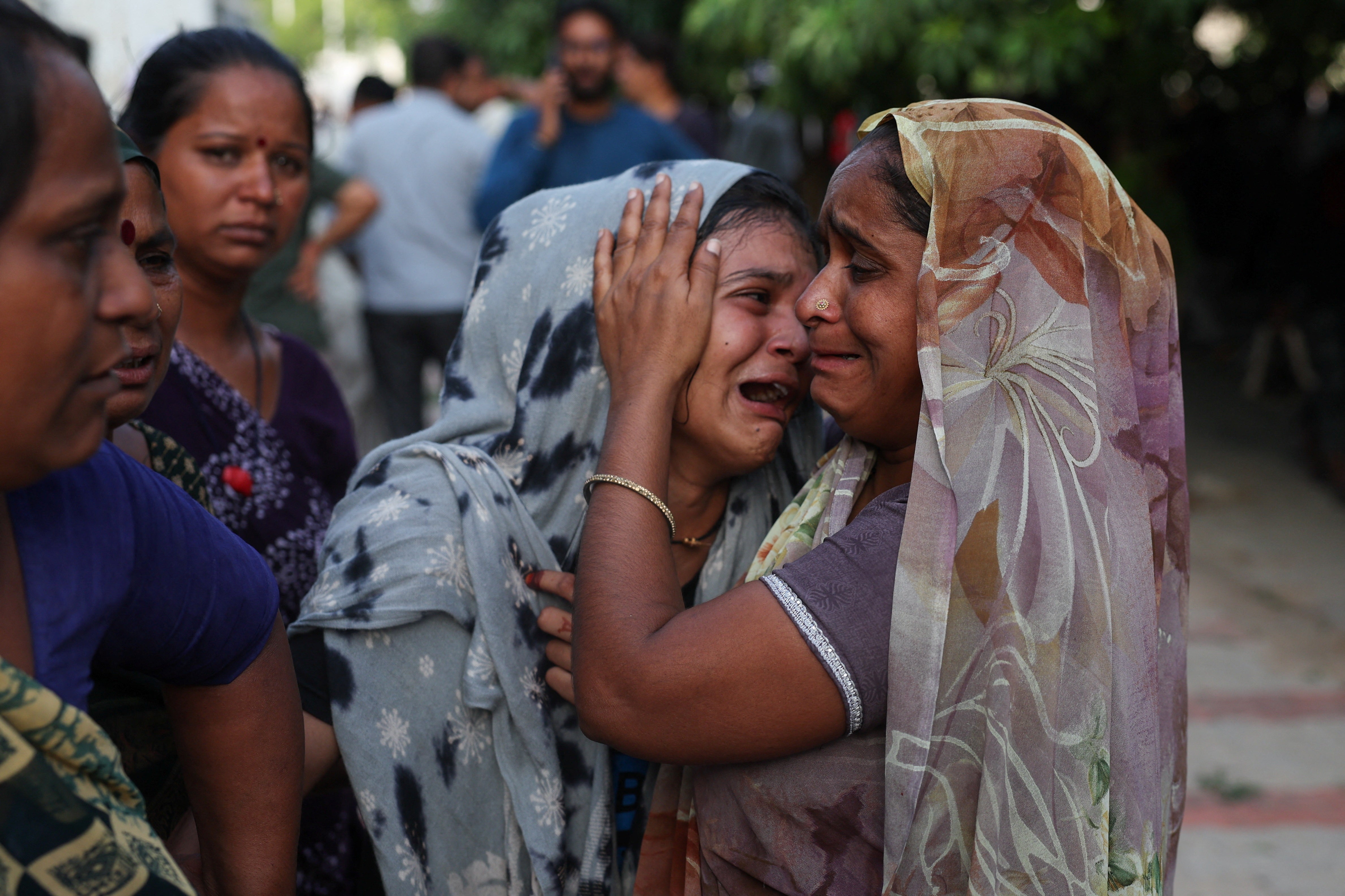 A family member cries upon hearing the news of her brother who died when the Air India Boeing 787 Dreamliner plane crashed in Ahmedabad