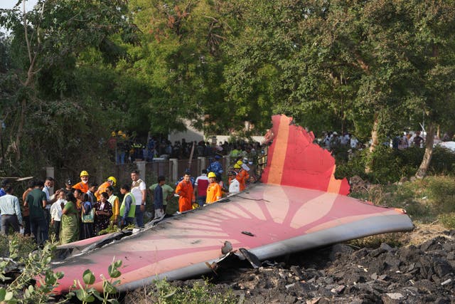 <p>Bystanders surrounding part of the plane wreckage</p>