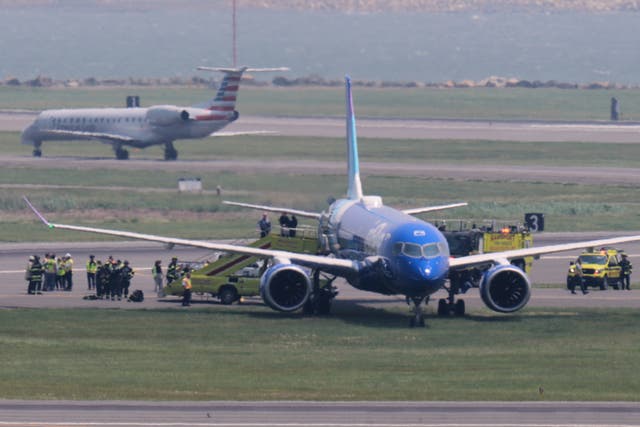 <p>Emergency responders surround a JetBlue plane which rolled off a runway onto a grass area while landing at Logan Airport</p>