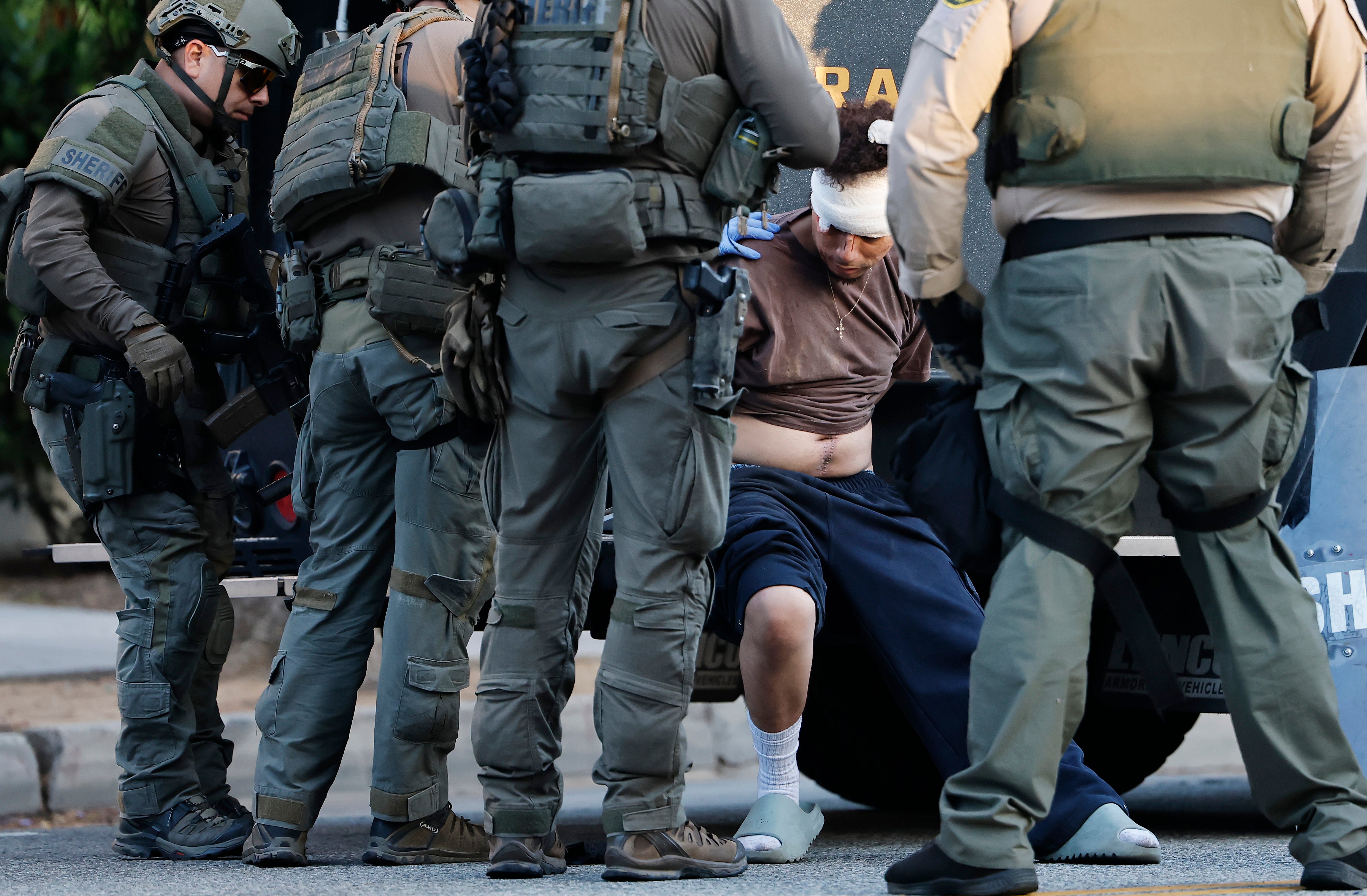 A detained person is treated for an injury by police in LA