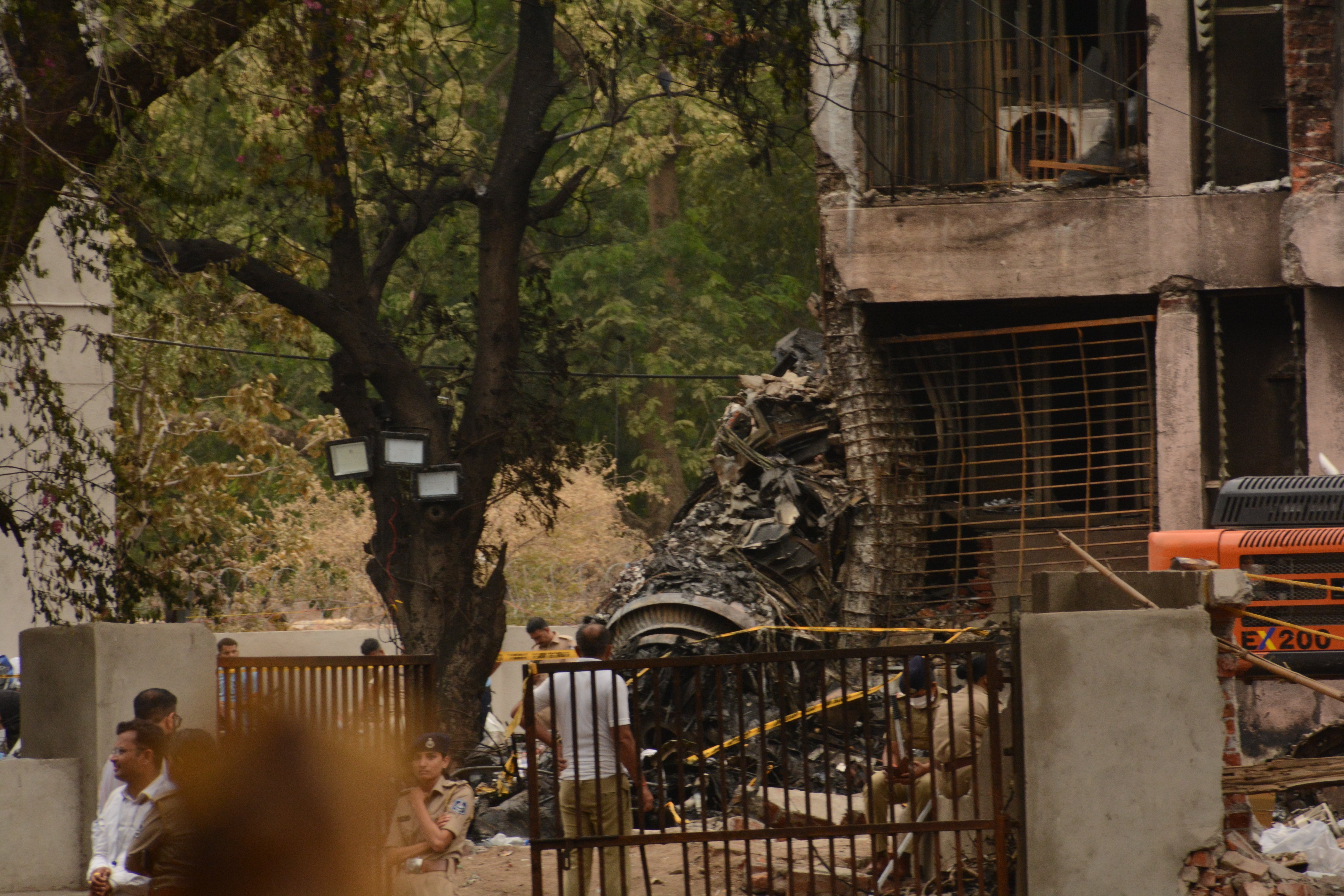 Officials work to clean wreckage after the Air India plane came down in a residential area