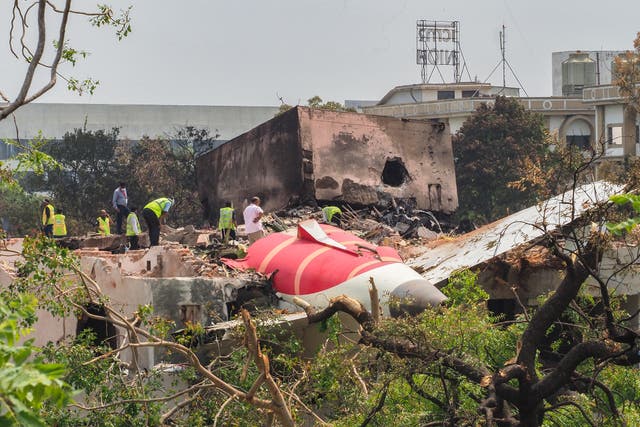 <p>An investigation team inspects the wreckage of Air India flight 171 a day after it crashed in a residential area near the airport in Ahmedabad on 13 June</p>