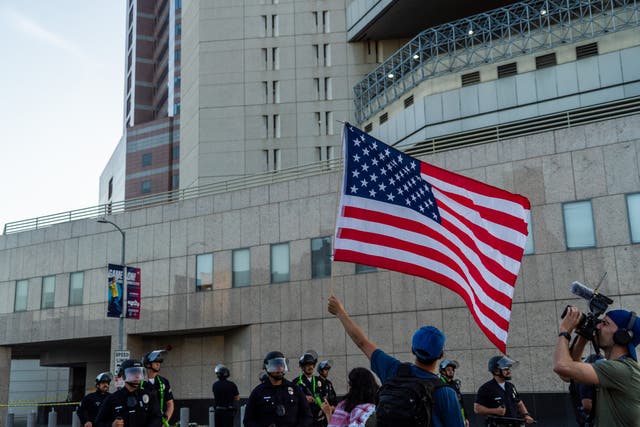 <p>Protesters rally outside the Metropolitan Detention Center in Los Angeles during the first night of curfew, where detained immigrants were seen flashing lights from the windows.</p>