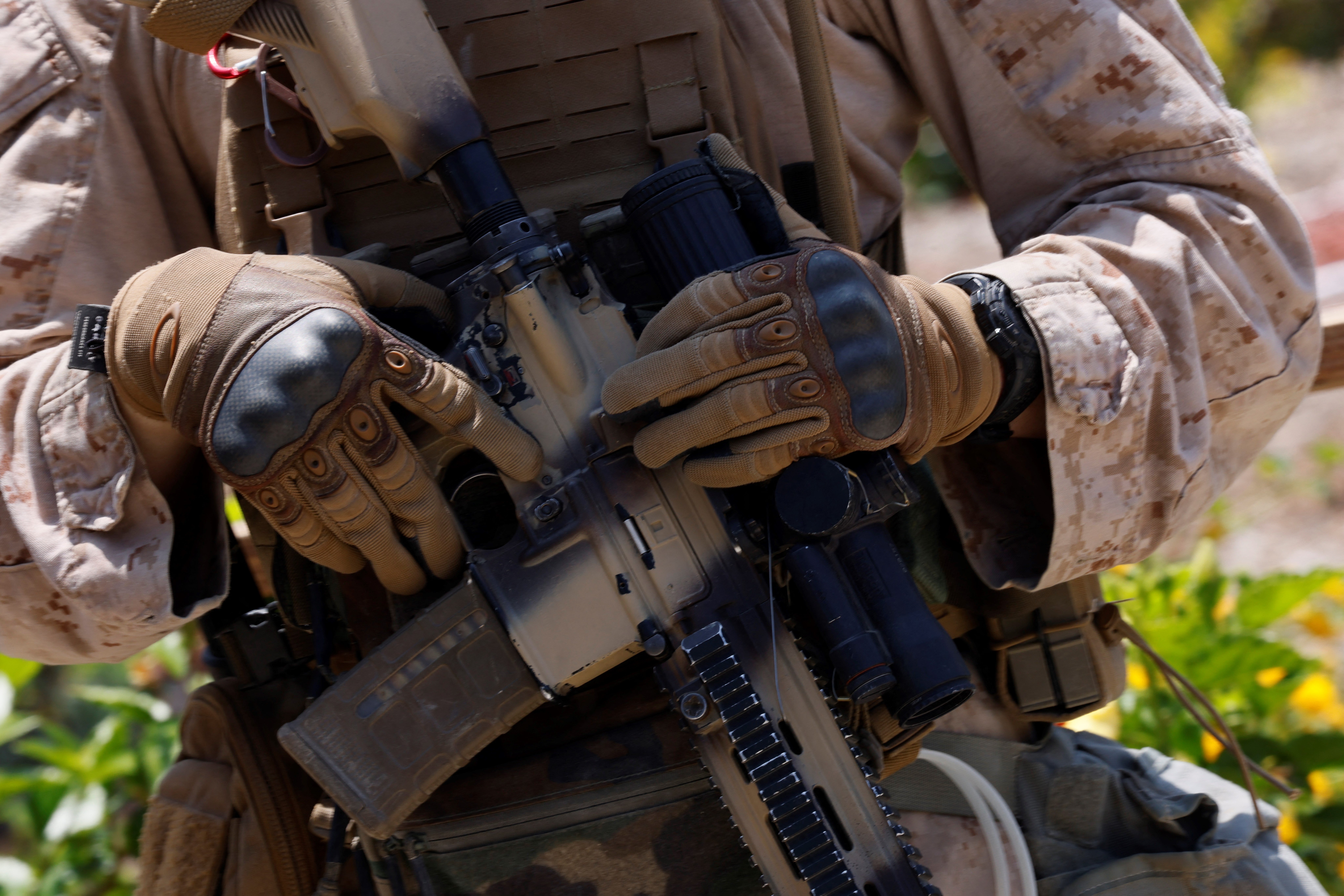 A Marine holds a gun as he guards one of the entrances to the Wilshire Federal Building in Los Angeles on Friday