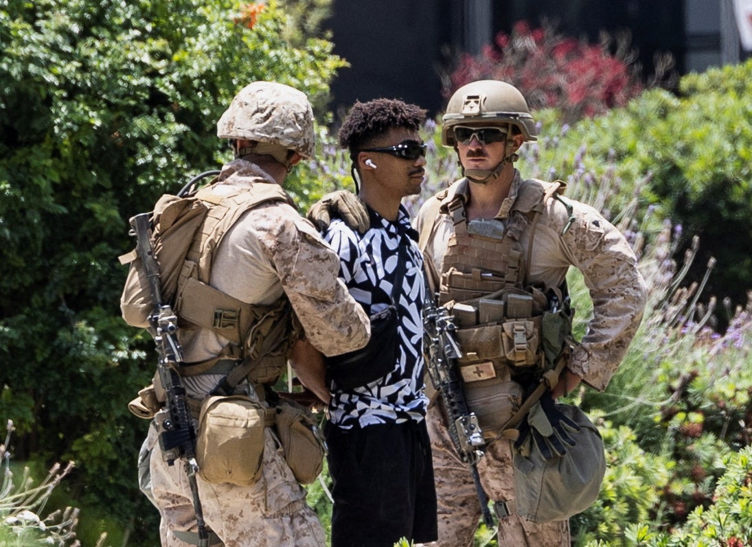 Marine and California National Guard members detain a person outside the Wilshire Federal Building in Los Angeles on Friday