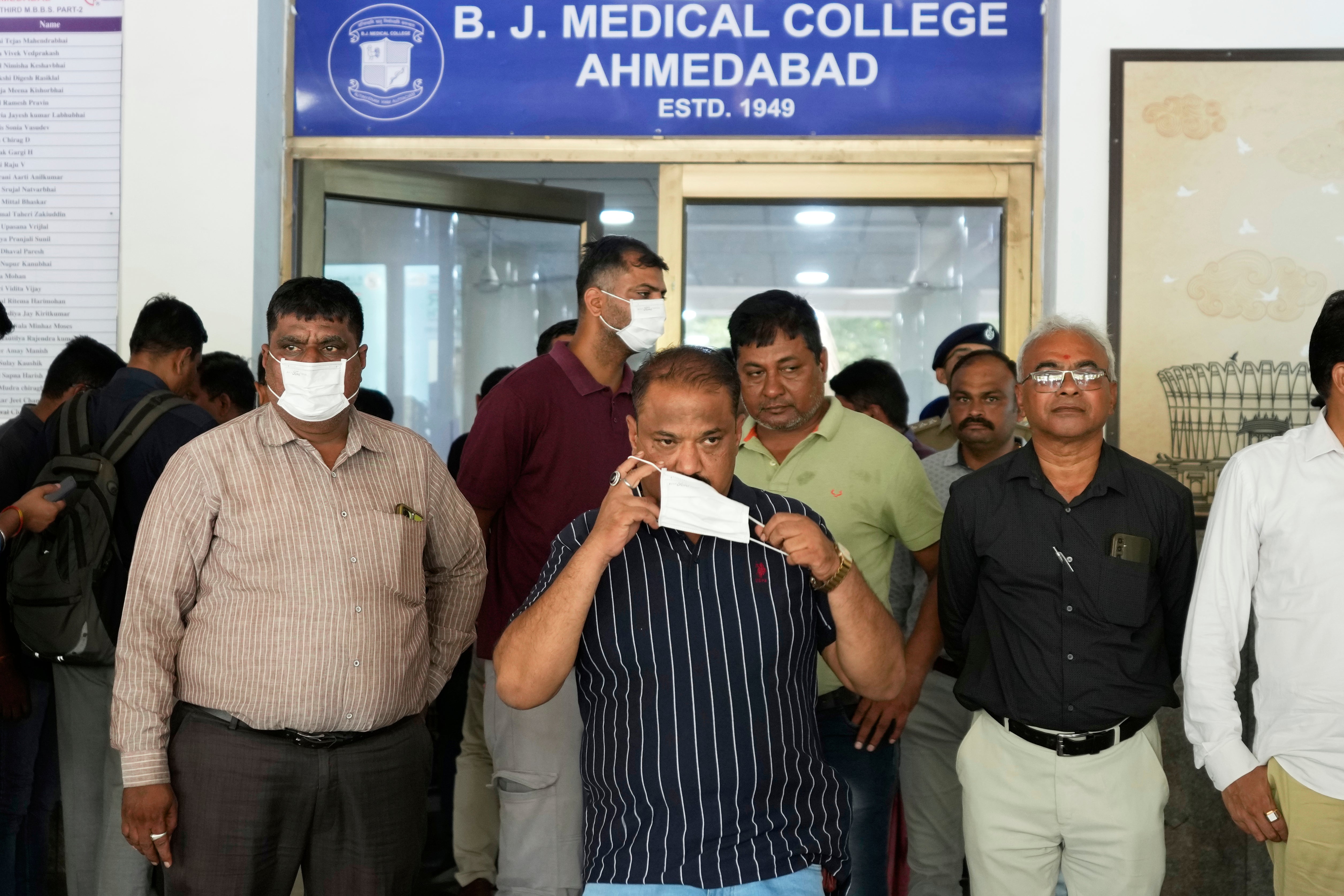 Relatives of the victims, who died in the Air India plane crash, wait outside the DNA collection center at a hospital in Ahmedabad, India, Saturday