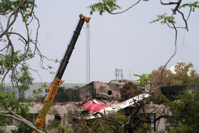<p>A crane works at the plane crash site</p>