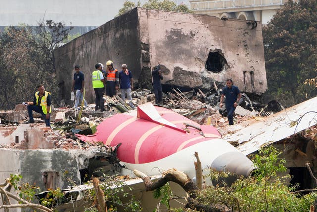 <p>Officials inspect the site of Thursday’s Air India plane crash (Ajit Solanki/AP)</p>