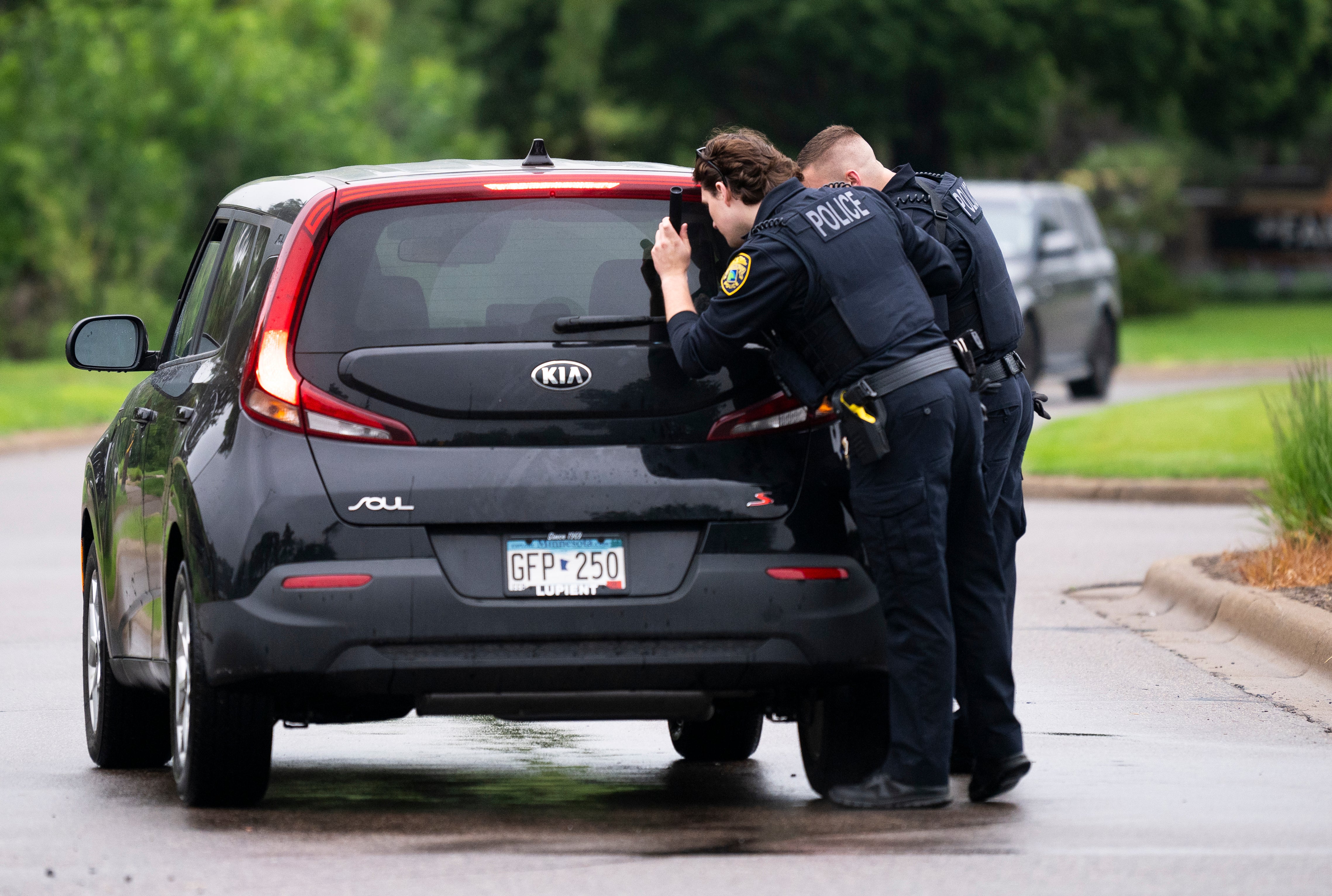 Officers search a vehicle entering a neighborhood on June 14 in Brooklyn Park, Minnesota