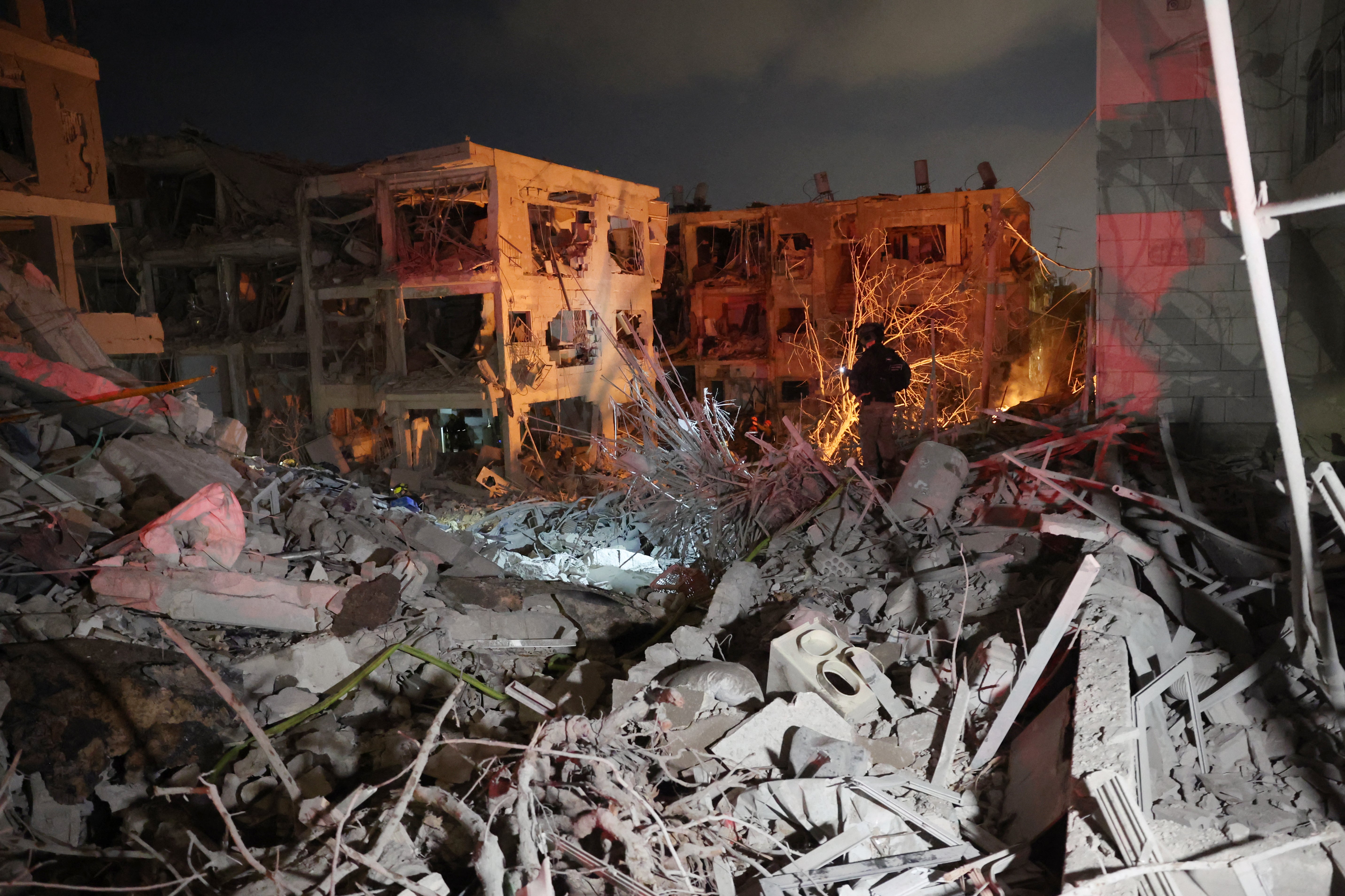 A responder stands amid building rubble following a hit by an Iranian ballistic missile in the Israeli city of Bat Yam, south of Tel Aviv, early on June 15, 2025.
