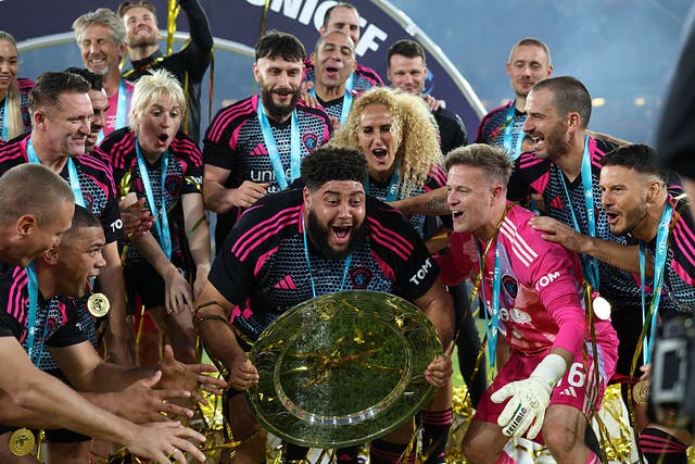 <p>British television presenter Zuhair Hassan known as Big Zuu lifts the trophy as World XI players celebrate their victory in the England XI v World XI charity football match for Soccer Aid for Unicef at Old Trafford in Manchester, north-west England on June 15, 2025. World XI won the game 5-4.</p>
