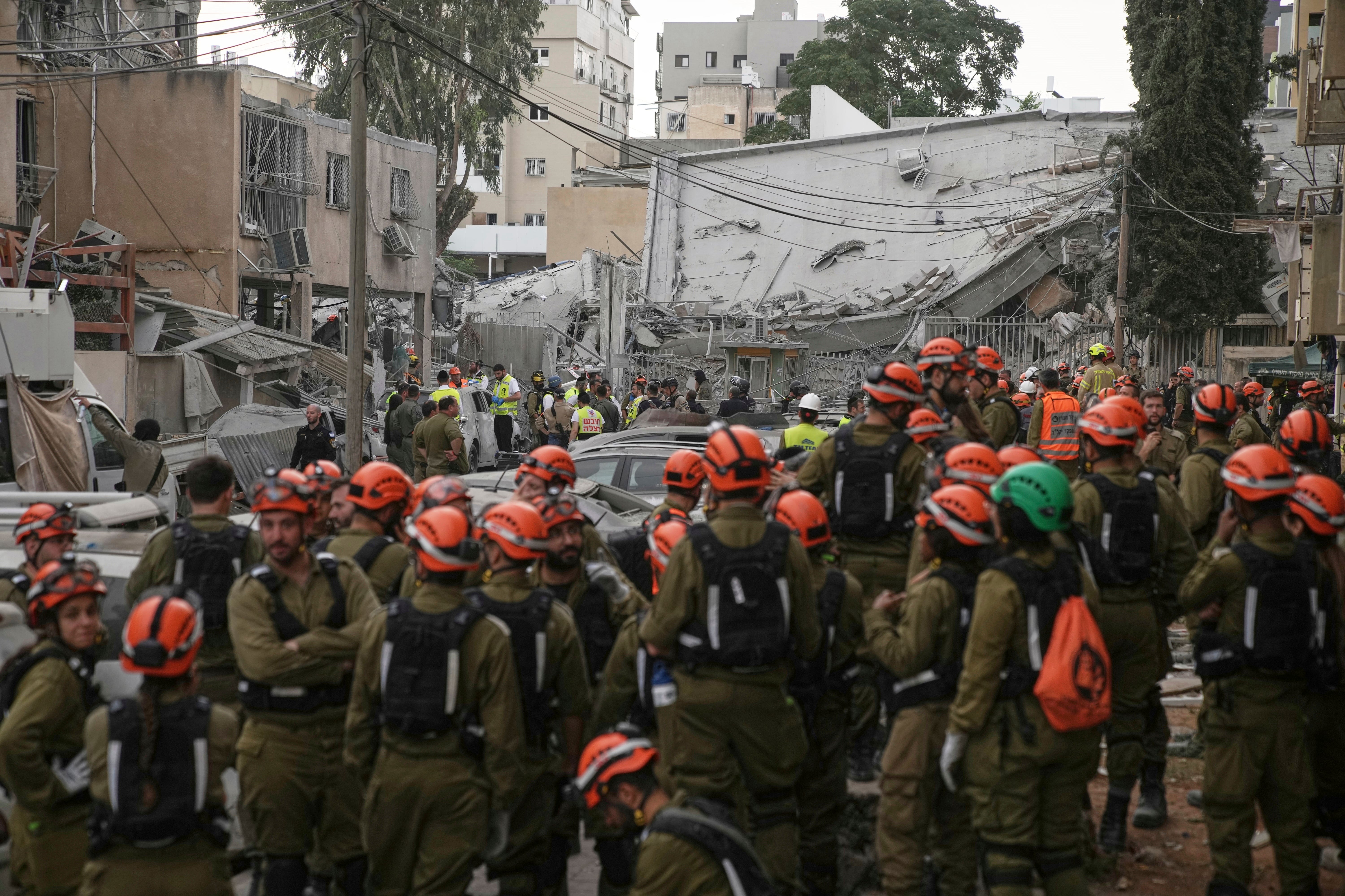 Rescue workers inspect the site where an Iranian missile struck in Bnei Brak, near Tel Aviv (Leo Correa/AP)