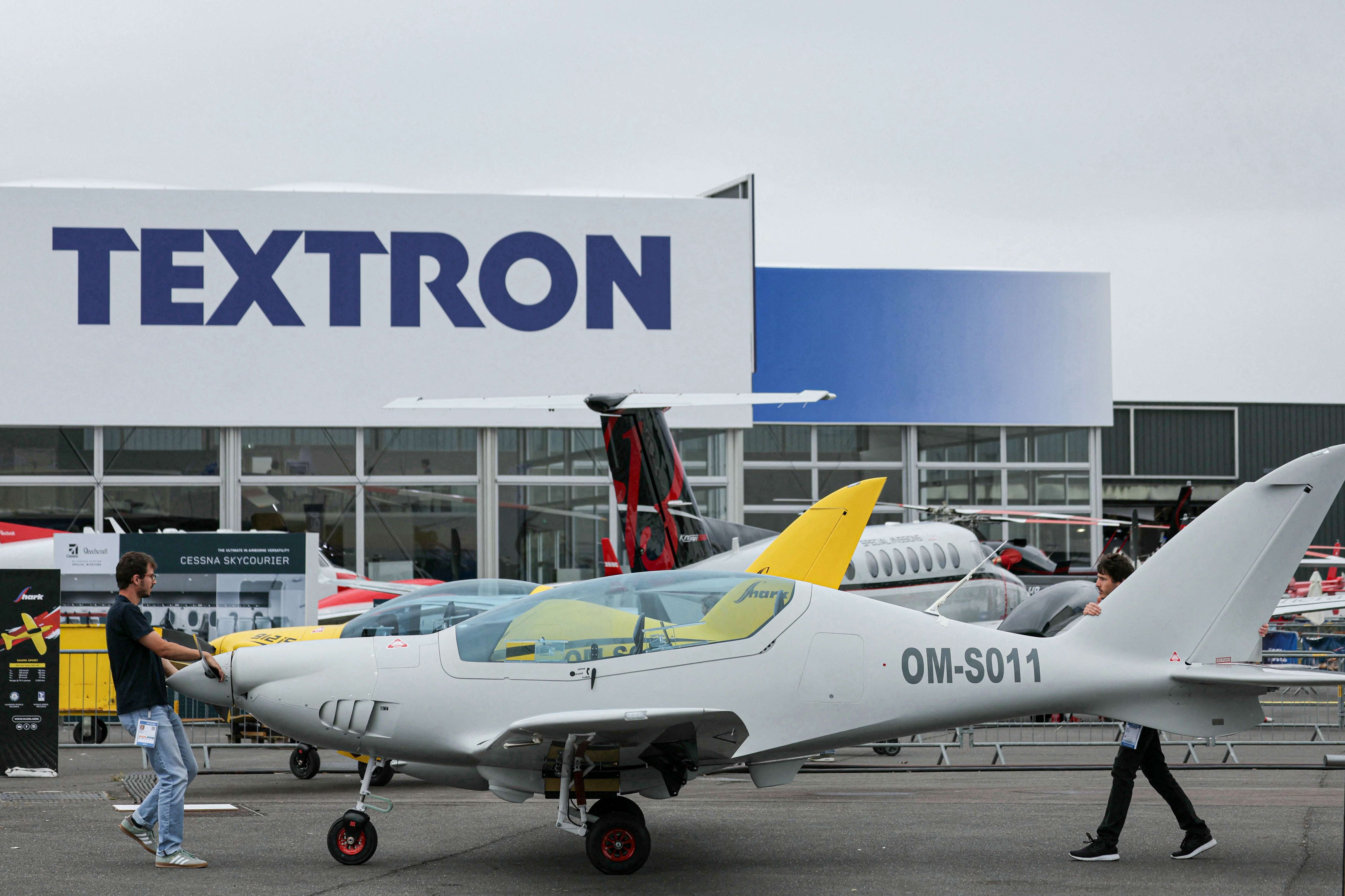 Los miembros del personal transportan un tiburón - OM -SO11 presentado por el fabricante de aviones eslovacos Shark. Aero durante la 55ª edición del International Paris Air Show