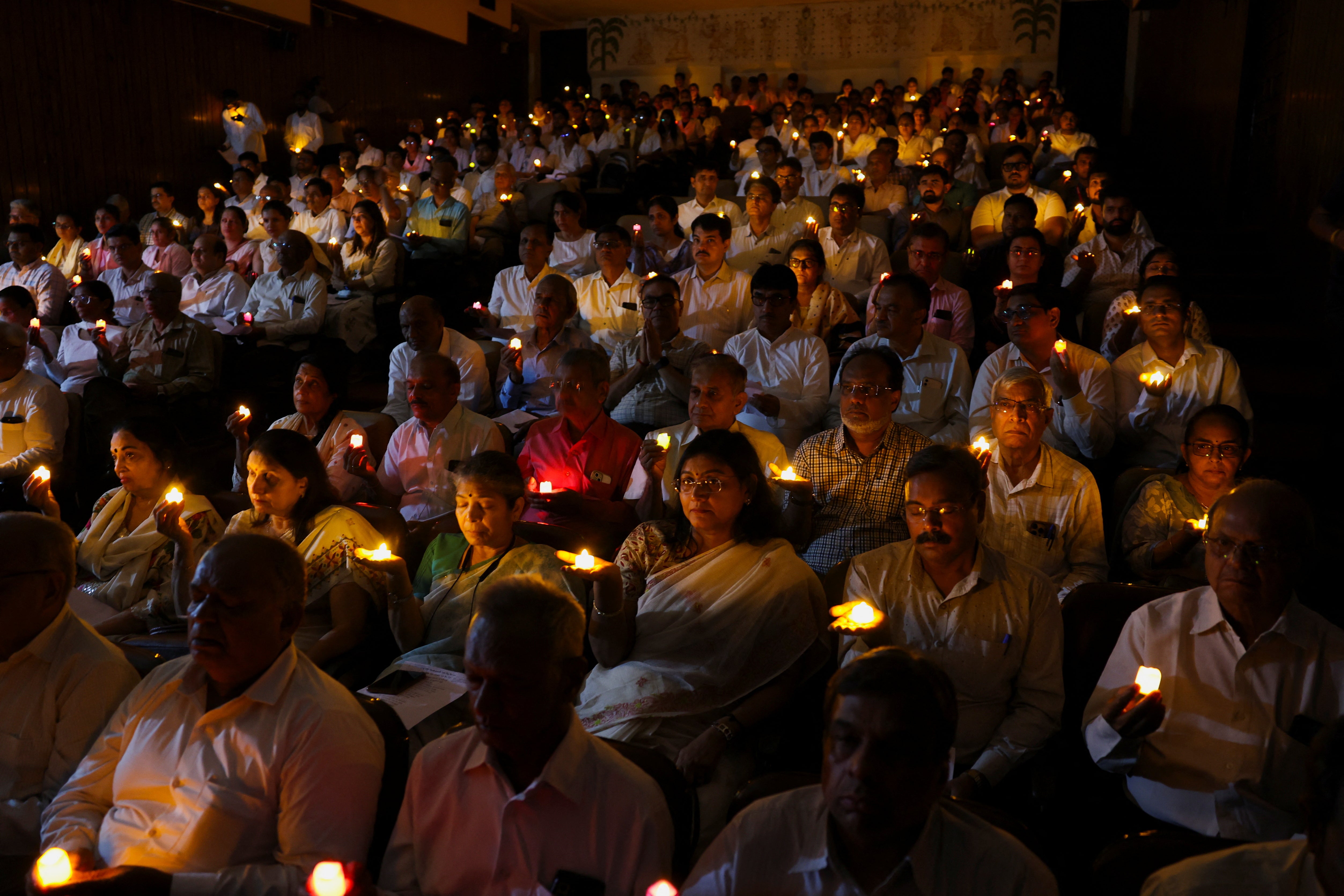 People hold candles as they take part in a special prayer ceremony for the victims of an Air India Boeing 787-8 Dreamliner plane, which crashed during take-off from an airport, in Ahmedabad, India, 17 June 2025