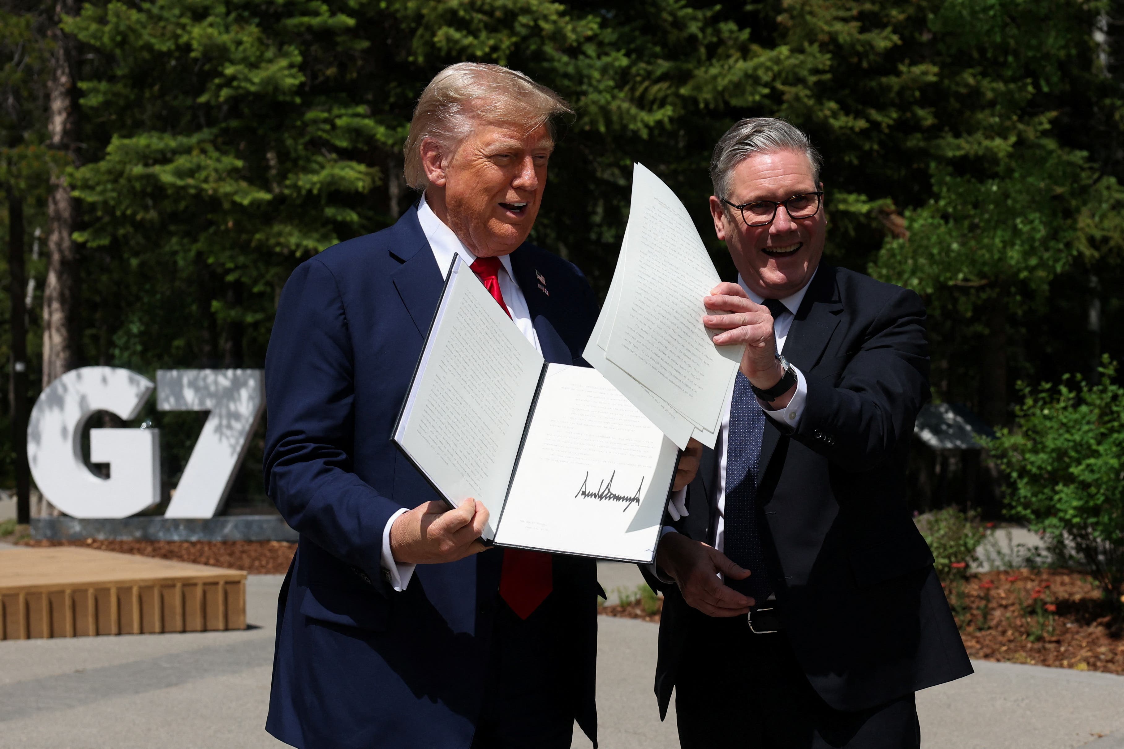 US President Donald Trump, left, holds the UK-US trade deal document with Prime Minister Sir Keir Starmer (PA)
