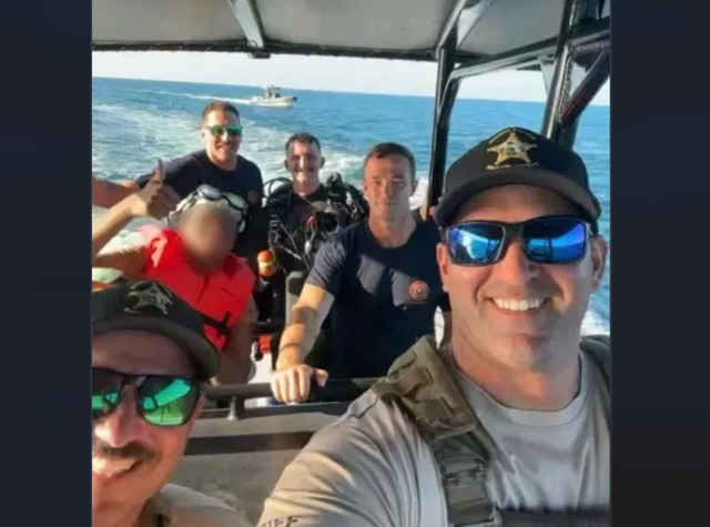 <p>A teen in Martin County, Florida gives a thumbs up as first responders return him to his family back on land</p>