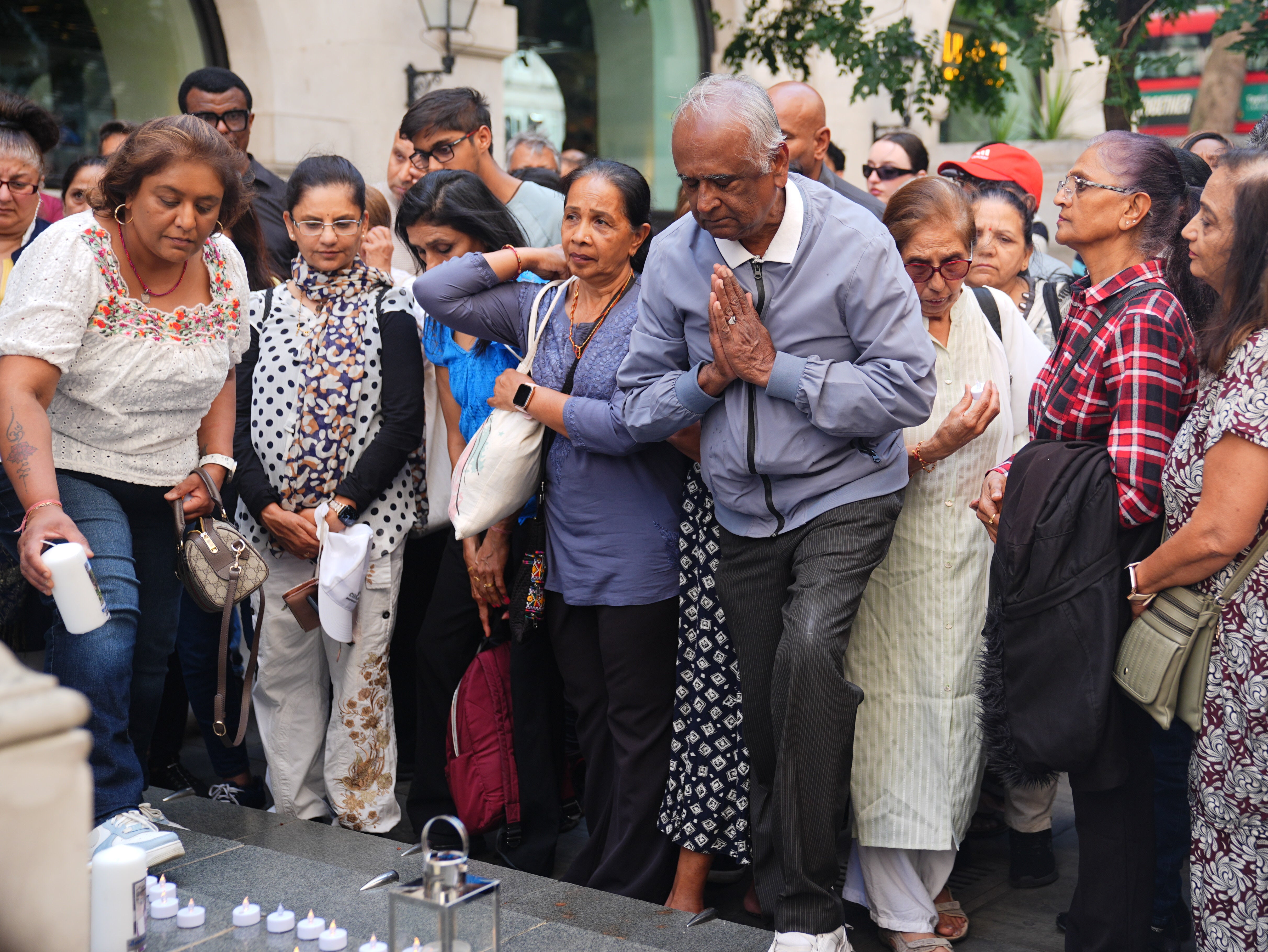 People participate in a candle light outside the India House, India's High Commission in London to honor the victims of Air India crash.