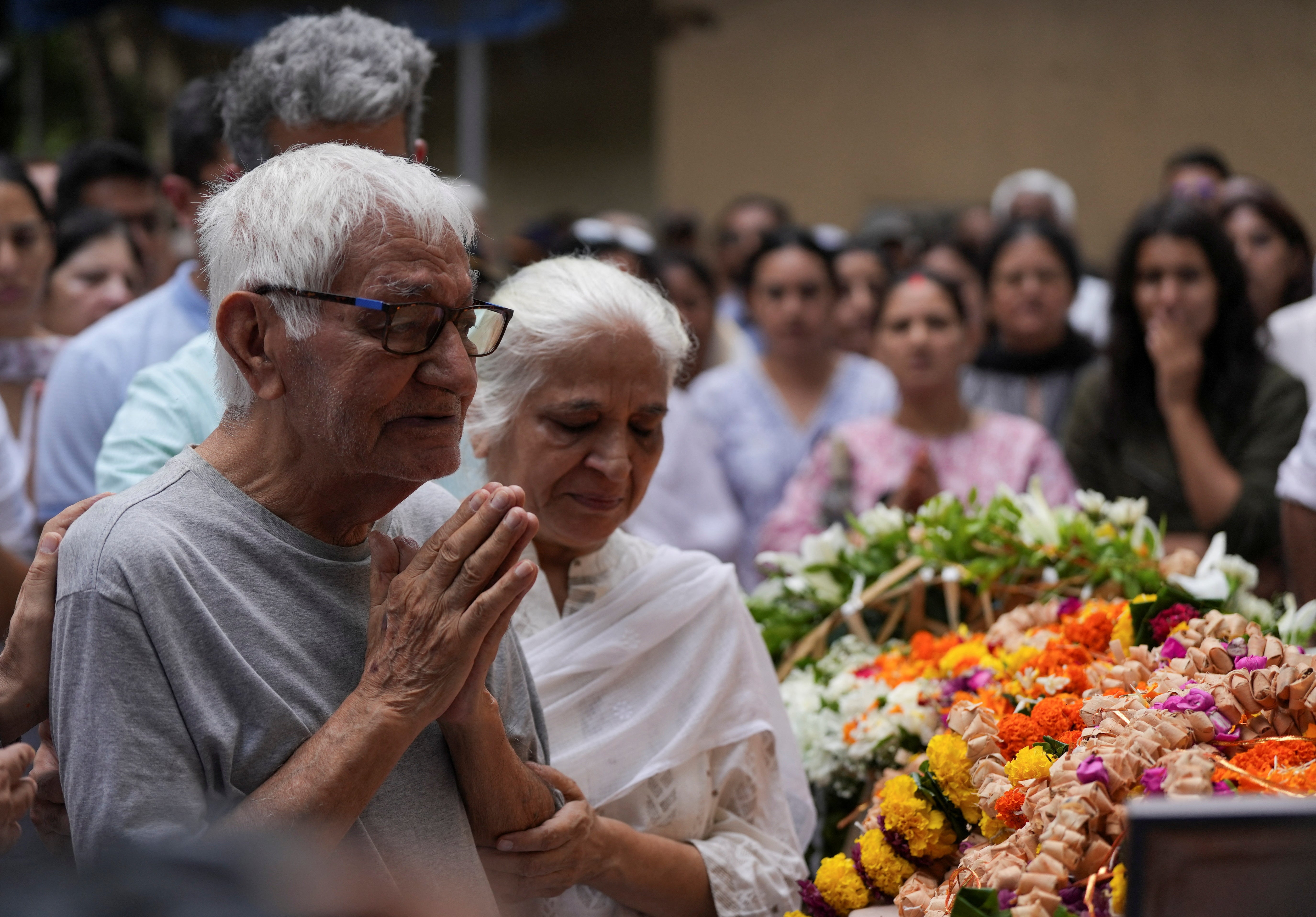 Father and mother of Sumeet Sabharwal, a pilot, who died when an Air India Boeing 787-8 Dreamliner aircraft crashed during take-off from an airport, offer prayer as they stand next to the body of their son in Mumbai, India, 17 June 2025