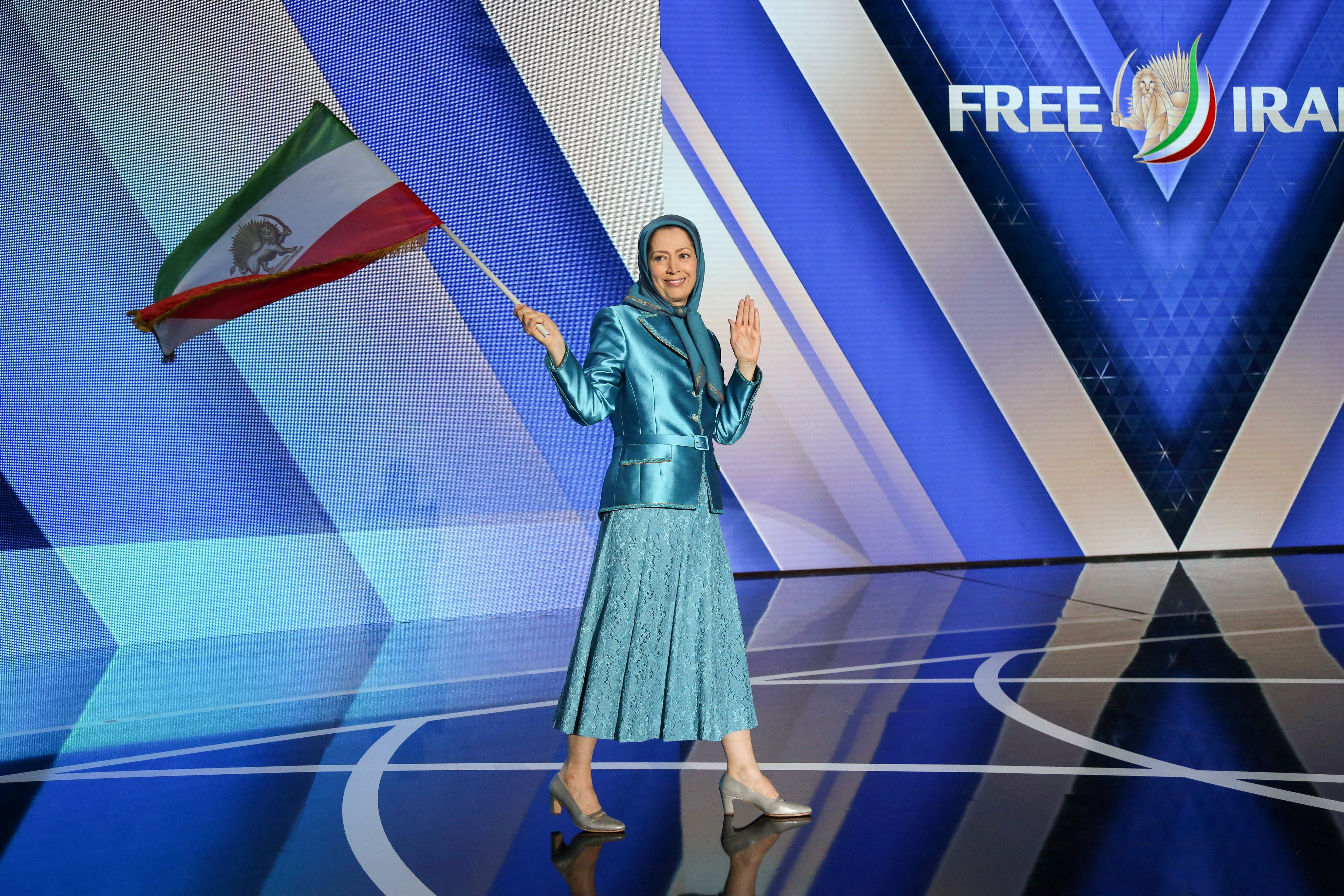 Maryam Rajavi, leader of the People's Mujahedin of Iran salutes her supporters as she arrives for the meeting