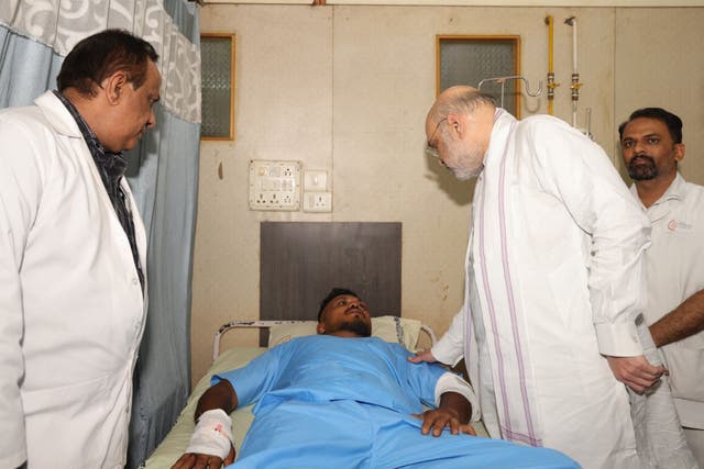 <p>Indian home affairs minister Amit Shah meeting Vishwash Kumar Ramesh in hospital in Ahmedabad (Ministry of Home Affairs India/PA)</p>