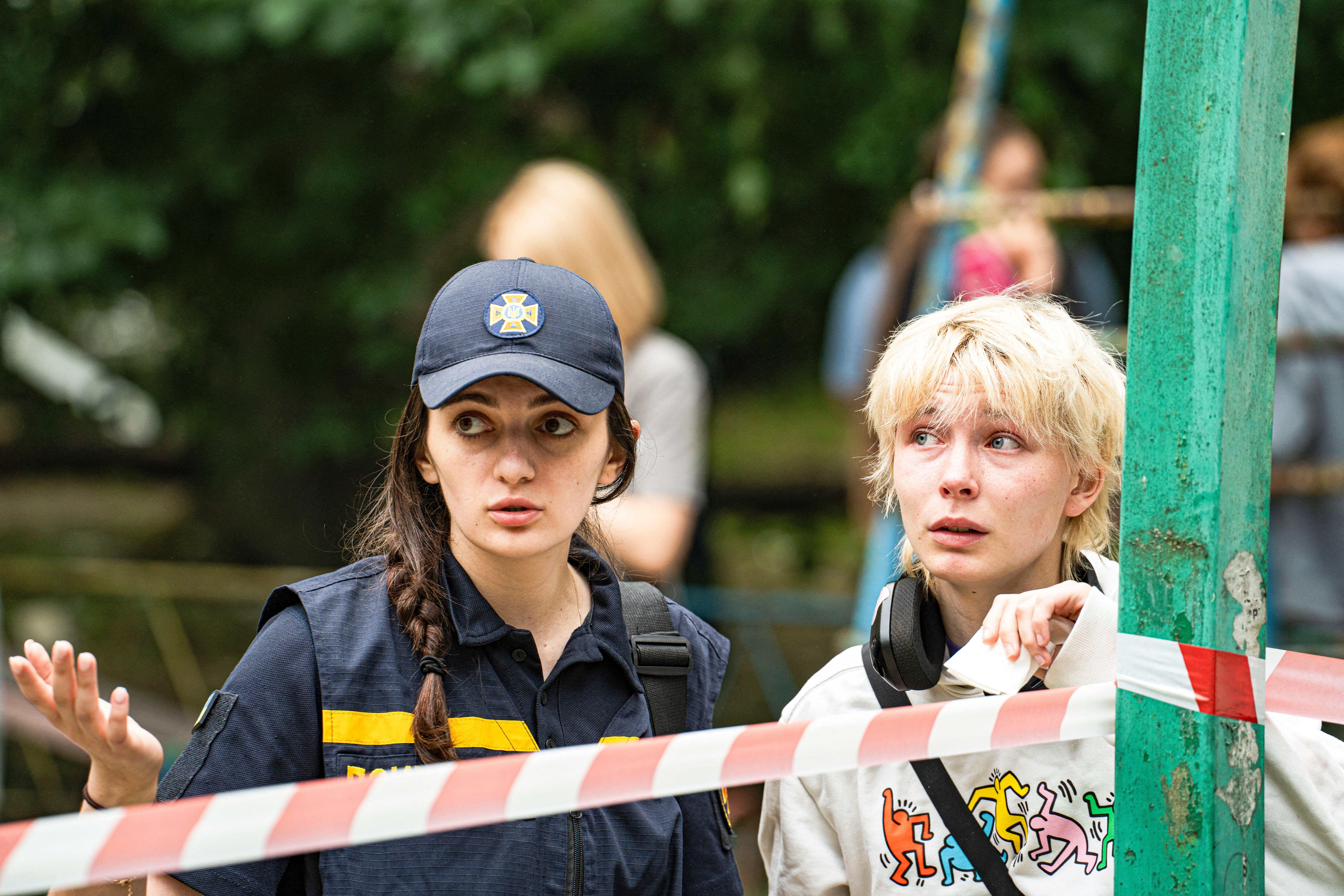 A Ukrainian woman talks with a first responder, as she awaits news of her loved ones likely buried under the rubble of a destroyed building in Kyiv where a whole building collapsed as a result of a direct missile hit