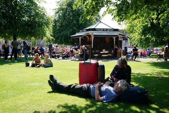 People enjoying the warm weather in Edinburgh’s Princes Street Gardens (Jane Barlow/PA)