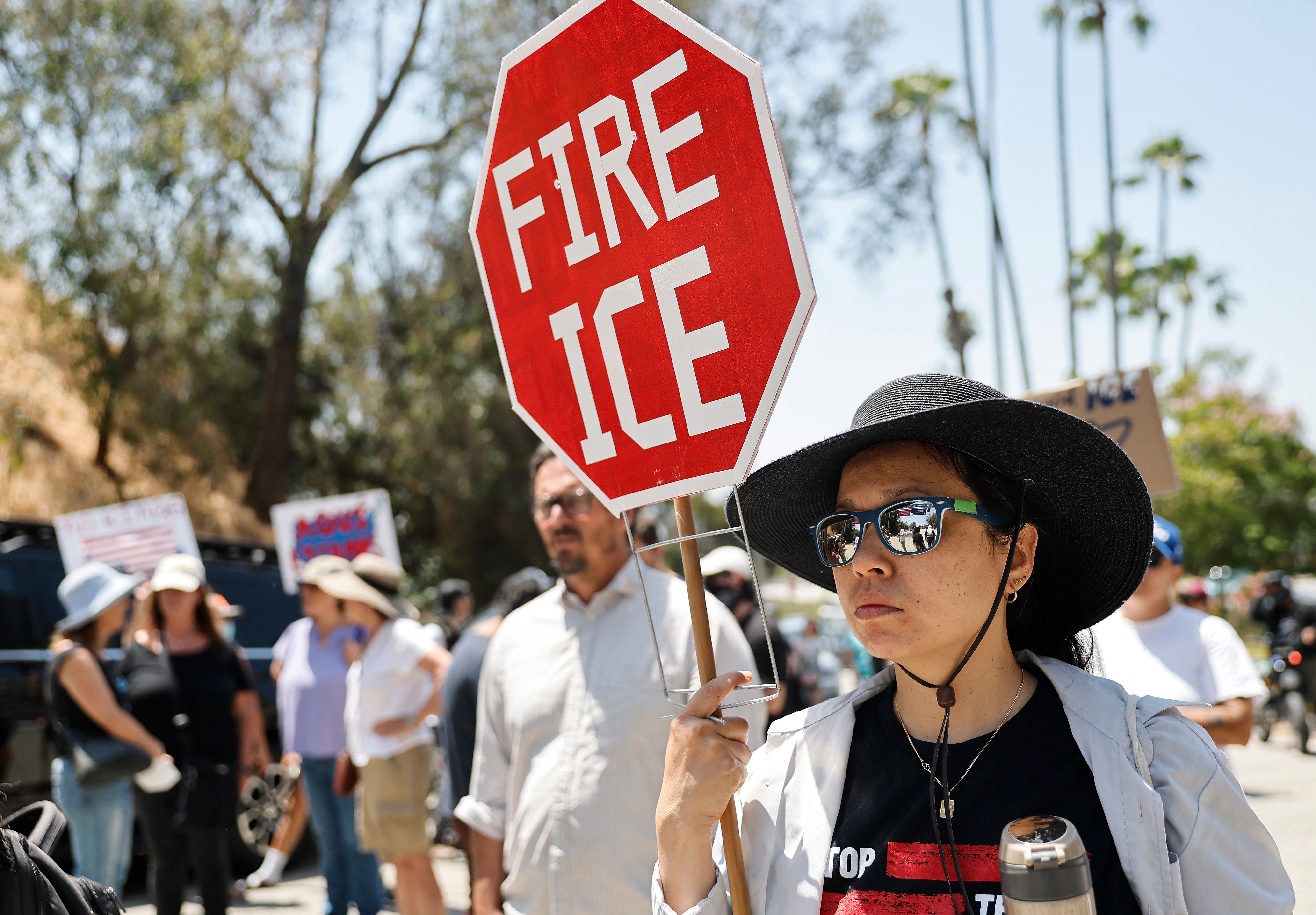 Protesters demonstrate not far from federal agents staged outside a gate of Dodger Stadium on June 19, 2025 in Los Angeles, California