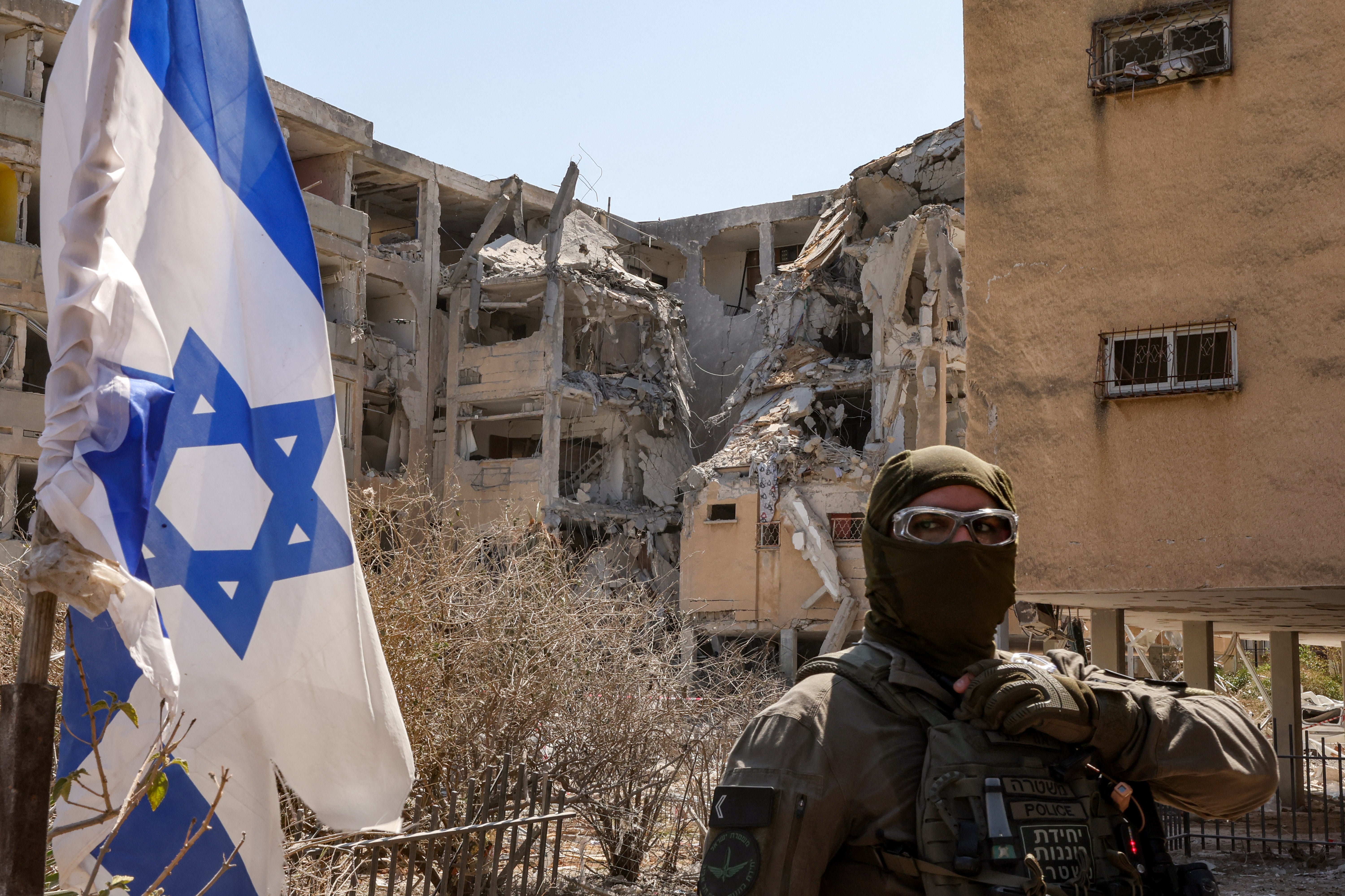 The world’s attention has now turned to Israel’s conflict with Iran. Here, a masked Israeli policeman stands guard outside a building in Holon that was hit by an Iranian missile