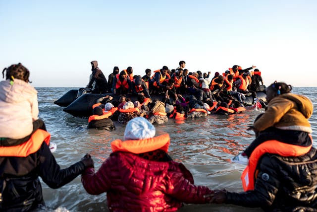<p>Migrants walking to board a smuggler's boat in an attempt to cross the English Channel off the beach of Gravelines, northern France on June 16, 2025</p>