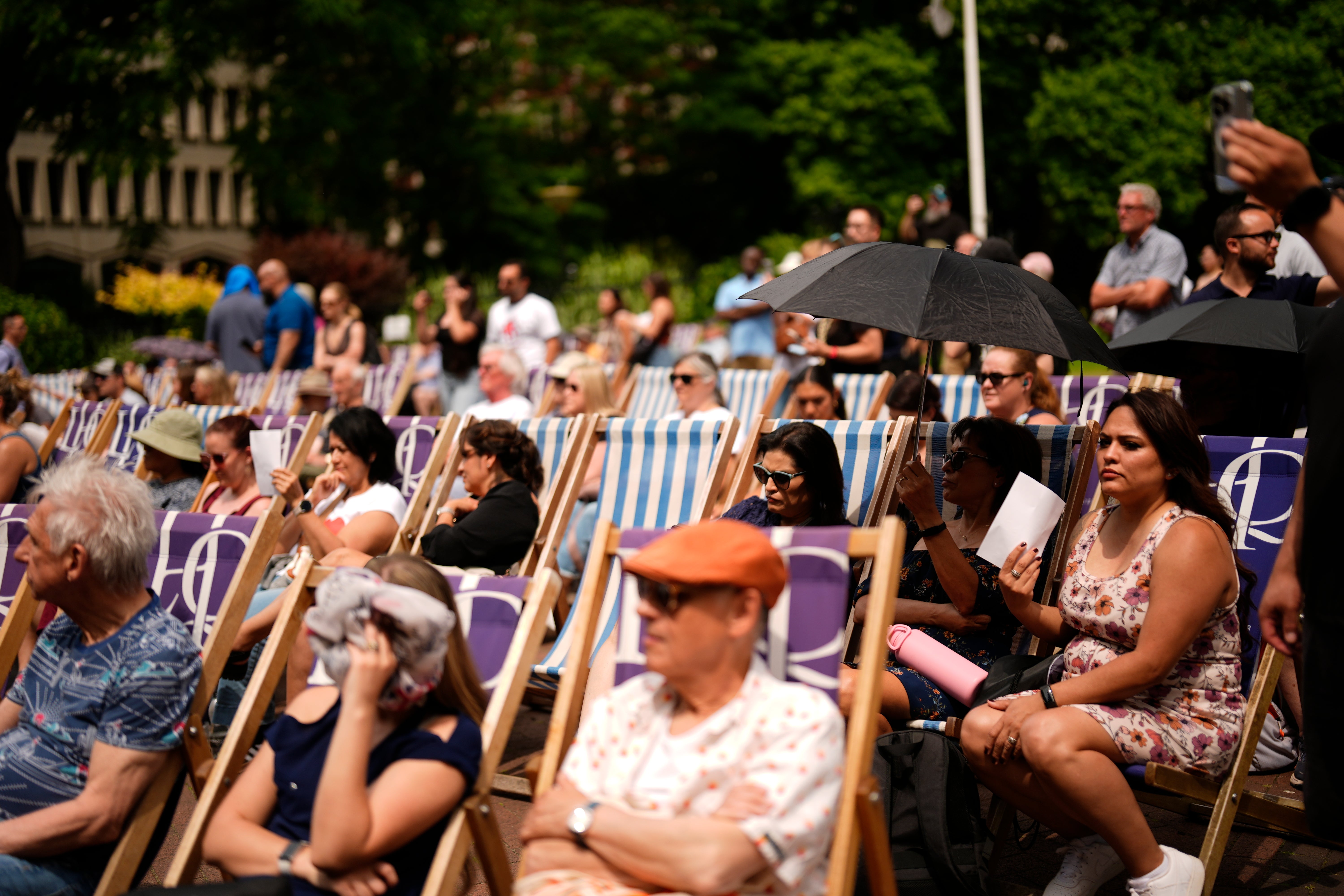 People enjoying the hot weather in Victoria Embankment Gardens, London