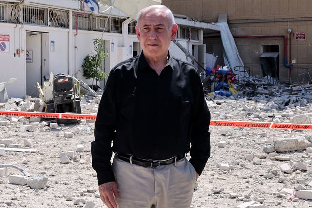 <p>Israeli Prime Minister Benjamin Netanyahu stands amid debris outside the Soroka Hospital in the southern city of Beersheba, after it was hit by a missile fired from Iran</p>