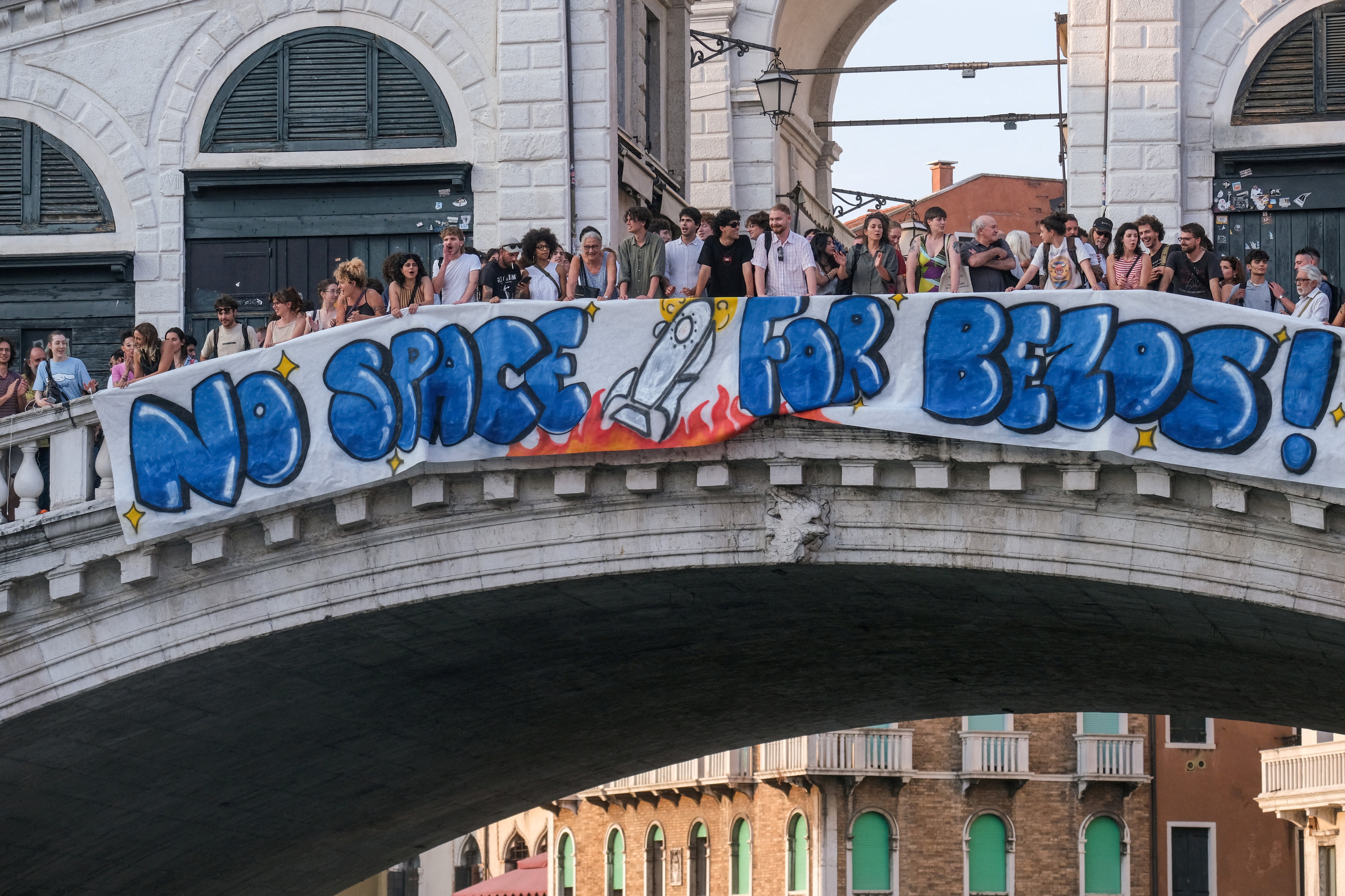 Protesters display a banner reading "No Space for Bezos!" on the Rialto Bridge during a protest against Amazon founder Jeff Bezos' upcoming wedding to Lauren Sanchez being held in Venice, Italy, June 13, 2025. REUTERS/Manuel Silvestri/File Photo