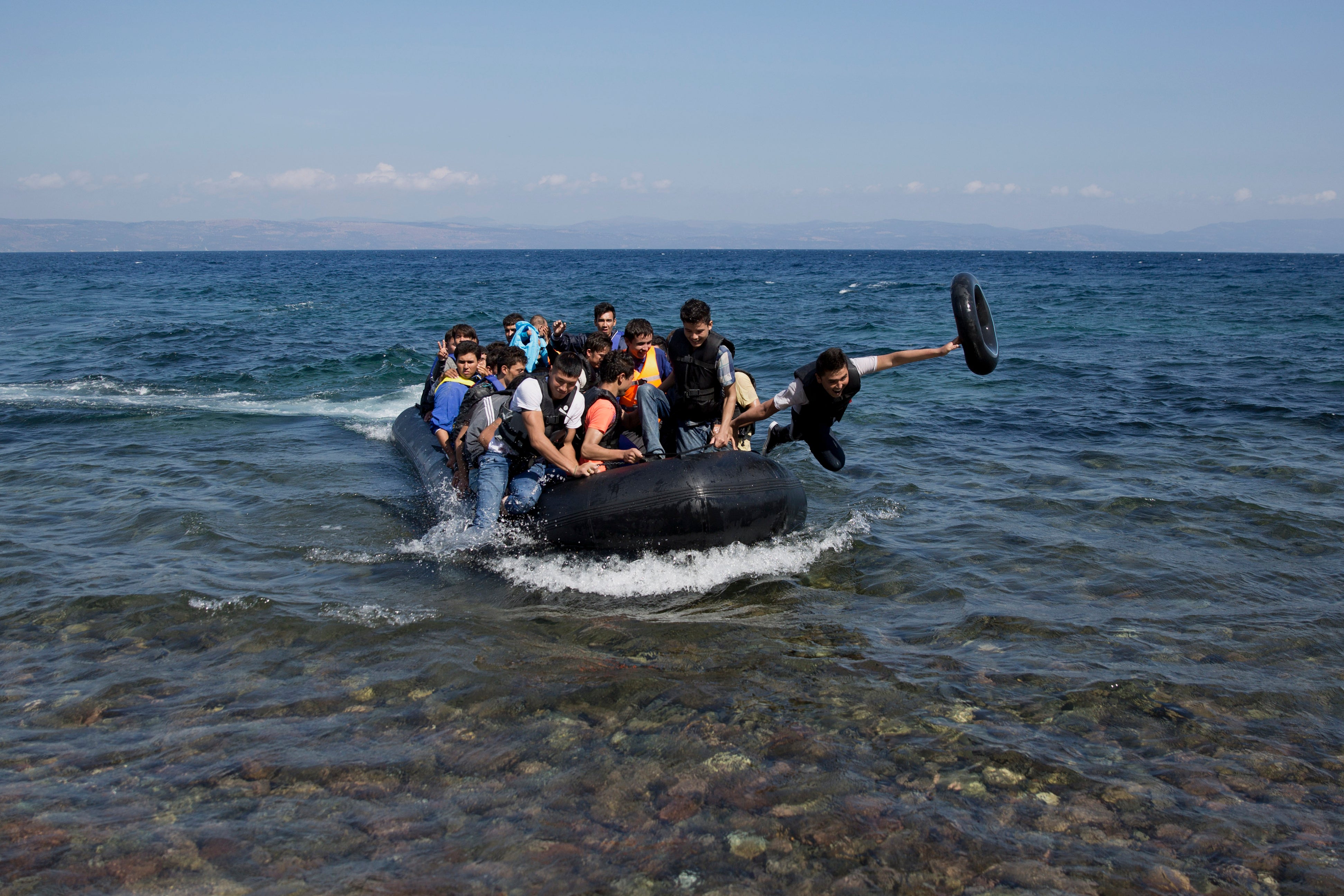 Afghan migrants arrive on the shores of the Greek island of Lesbos after crossing the Aegean sea from Turkey on a inflatable dinghy, Friday, Sept. 25, 2015