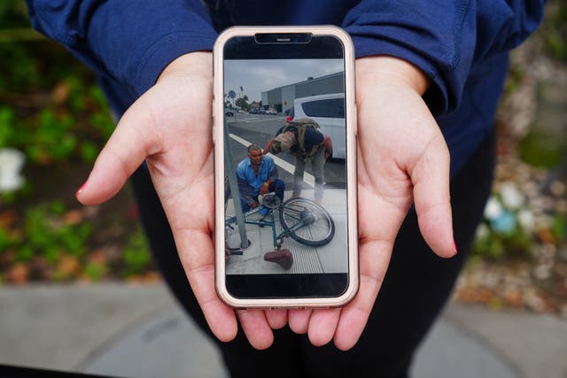 <p>Melyssa Rivas shows her video of masked federal agents detaining a person earlier this month outside Our Lady of Perpetual Help Catholic Church in Downey, Calif., on Friday, June 20, 2025. (AP Photo/Damian Dovarganes)</p>