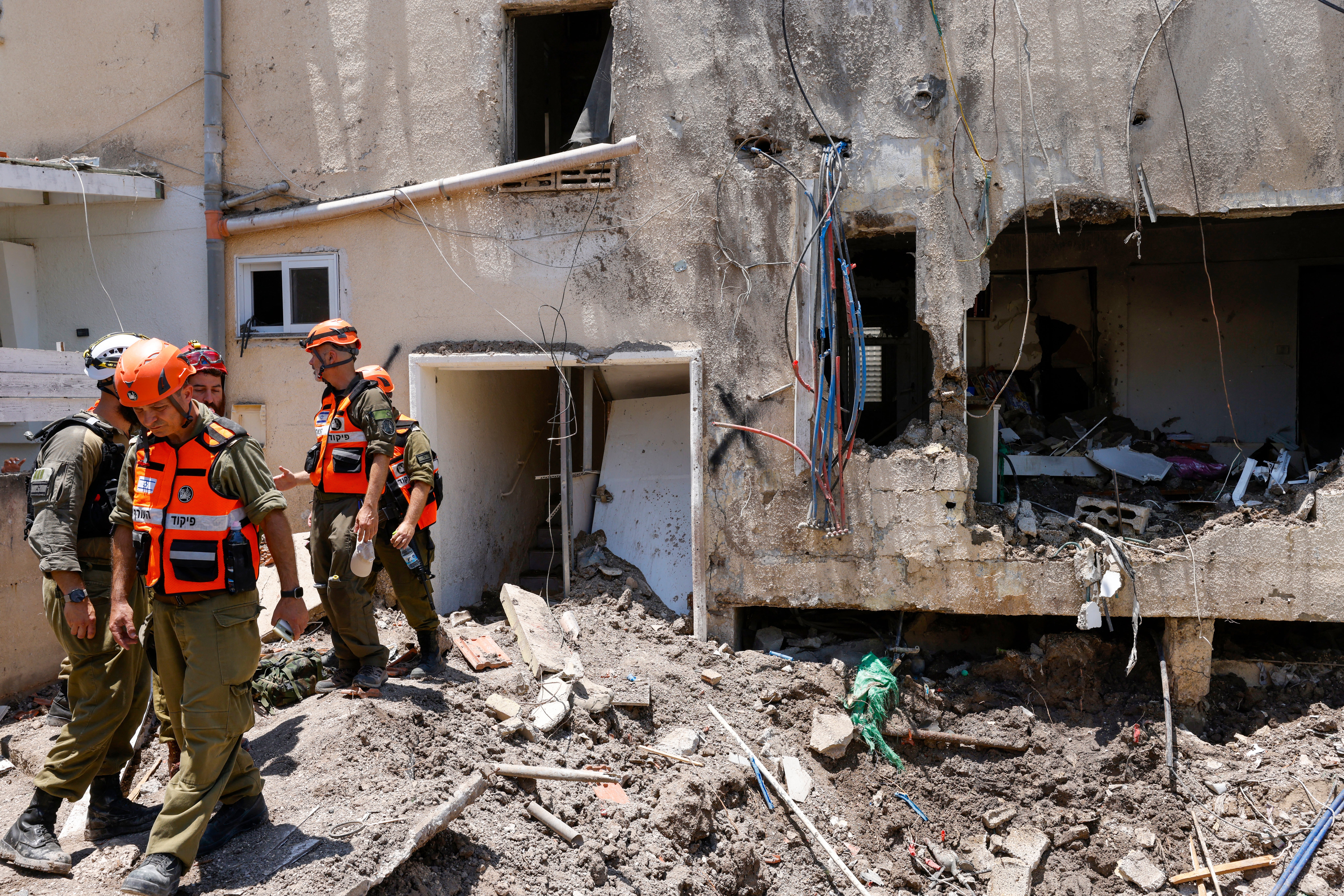 Israeli soldiers and first responders check the damage caused to a building from an Iranian strike in Beit She'an on June 21