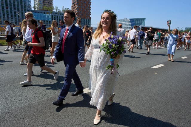 <p>Zuzana Lisowska and Yuri Iozzelli celebrate after getting married on a highway bypass, as the Dutch capital celebrates its 750th anniversary with weddings, music and other events on the A10 ring road in Amsterdam, Netherlands, Saturday, June 21, 2025. (AP Photo/Peter Dejong)</p>