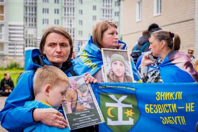 <p>Ukrainians hold photos of their missing relatives during as they watch freed Ukrainian soldiers arrive after a POW exchange with Russia in the Chernyhiv region of Ukraine, Friday, June 20, 2025. (AP Photo/Dan Bashakov)</p>