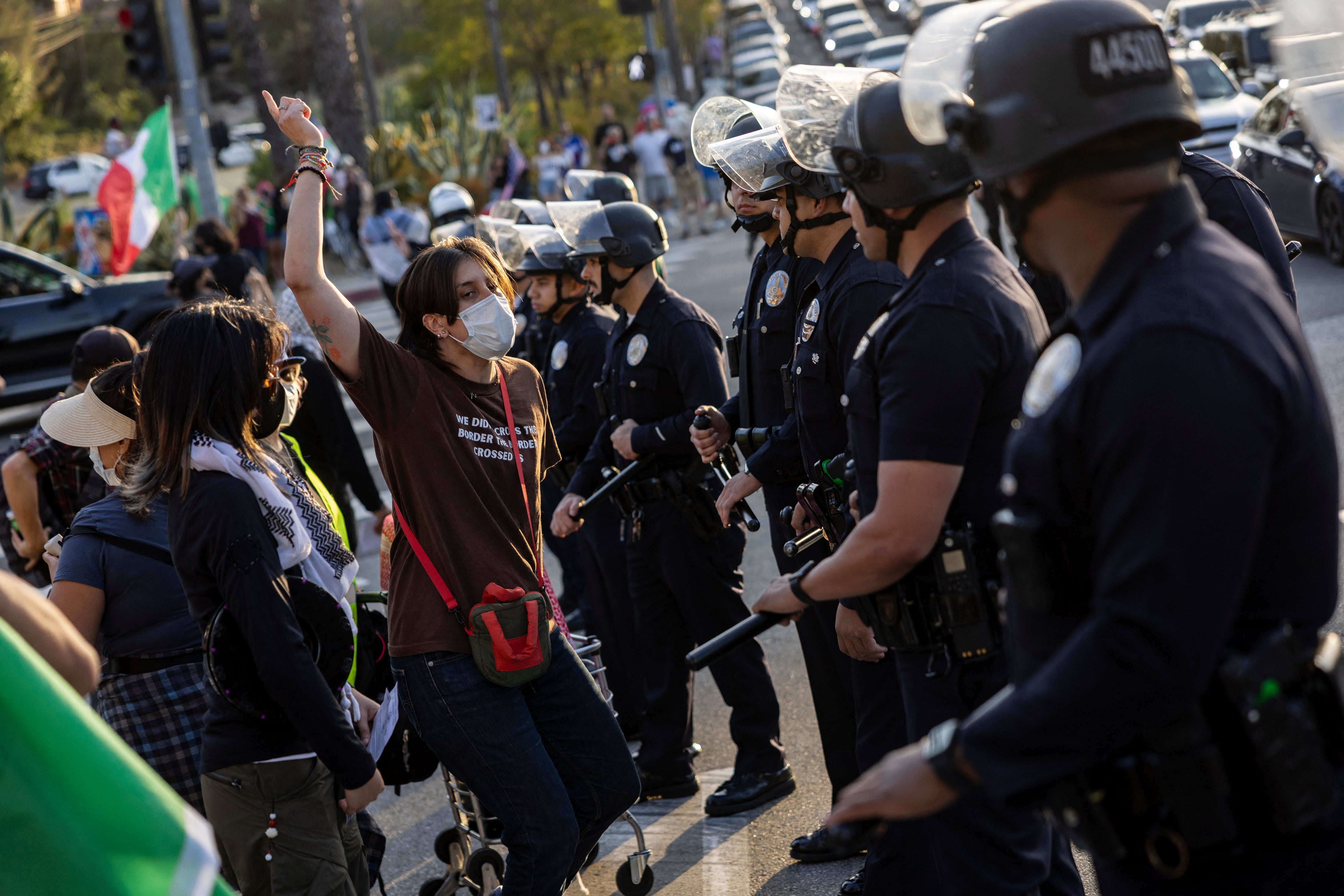 Police officers face down protesters in front of the main entrance of Dodger Stadium as they gather to call for a boycott of the team, claiming the organization supports federal immigration efforts, in Los Angeles, on Thursday