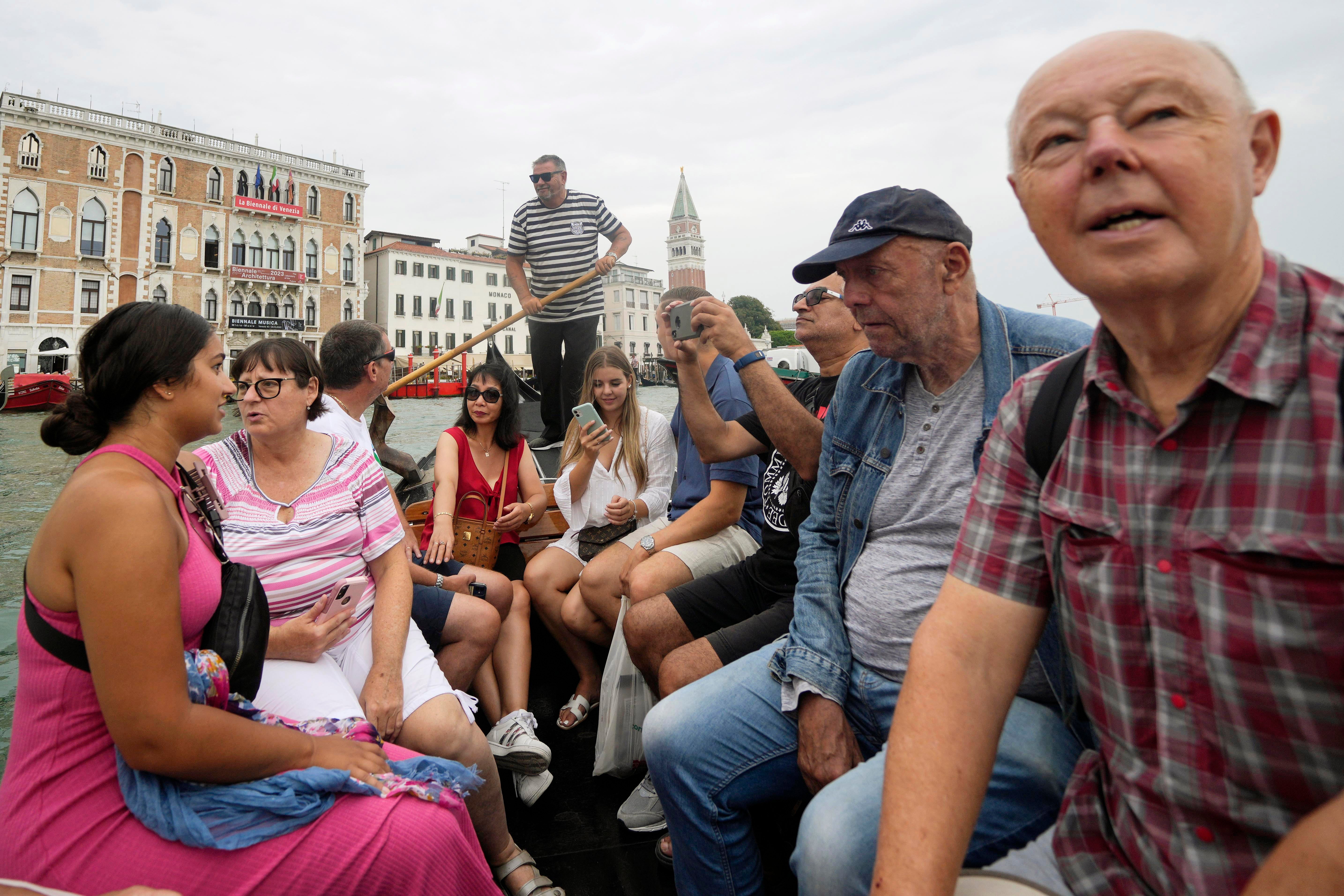 Tourists sit in a gondola during a short crossing of a canal, in Venice, Italy, Wednesday, Sept. 13, 2023. (AP Photo/Luca Bruno, File)