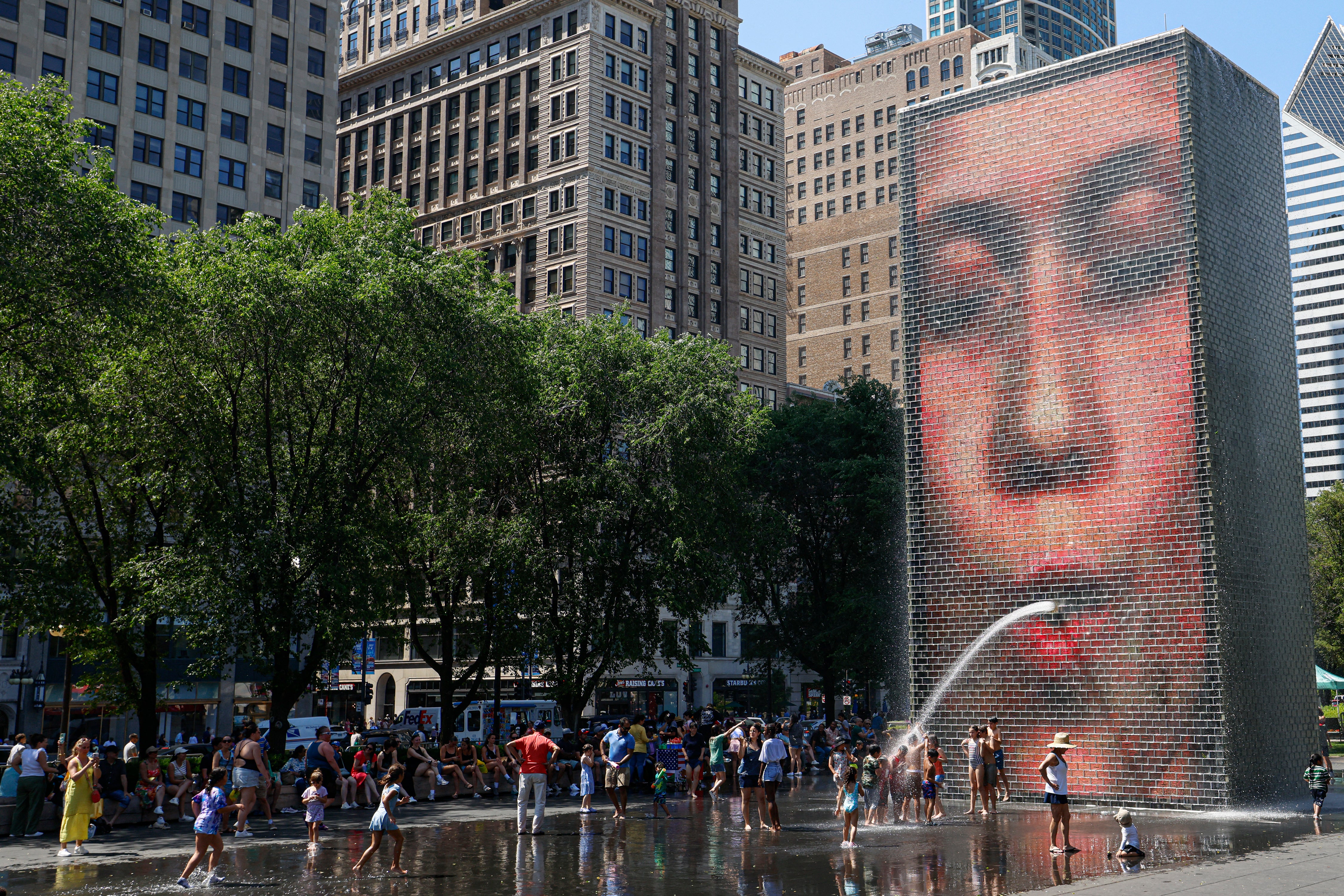 People cool off in Crown Fountain in Millennium Park as temperatures climbed to over 95 degrees Fahrenheit (35 degrees Celsius), in Chicago