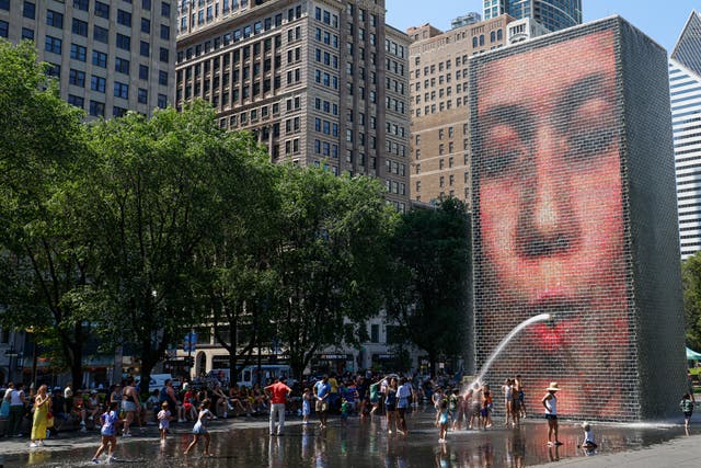 <p>People cool off in Crown Fountain in Millennium Park as temperatures climbed to over 95 degrees Fahrenheit</p>