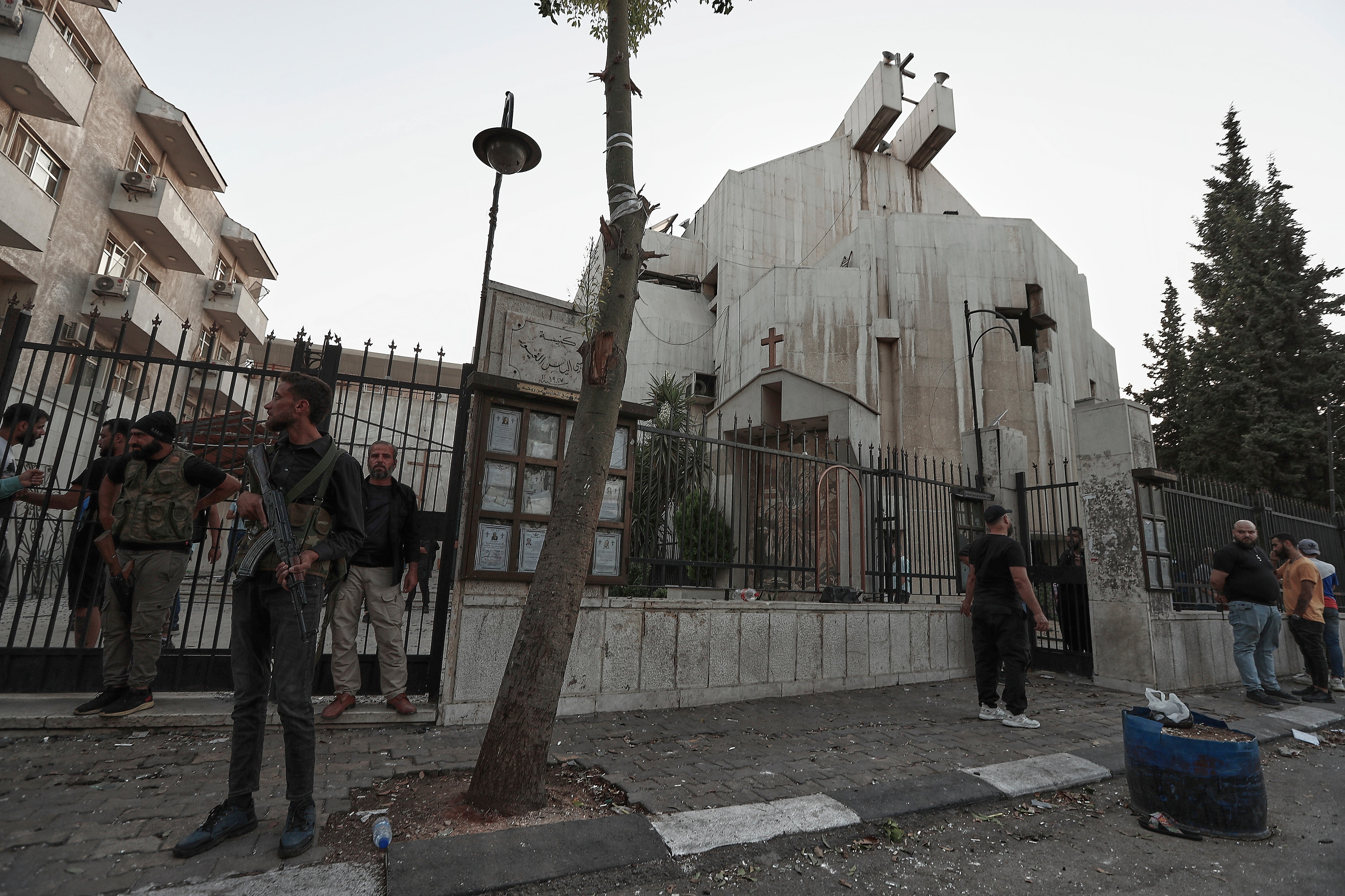 Syrian security forces stand guard outside Mar Elias church where a suicide bomber detonated himself in Dweil'a in the outskirts of Damascus, Syria, Sunday June 22, 2025. (AP Photo/Omar Sanadiki)