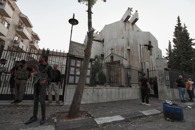 <p>Syrian security forces stand guard outside Mar Elias church where a suicide bomber detonated himself in Dweil'a in the outskirts of Damascus, Syria, Sunday June 22, 2025. (AP Photo/Omar Sanadiki)</p>