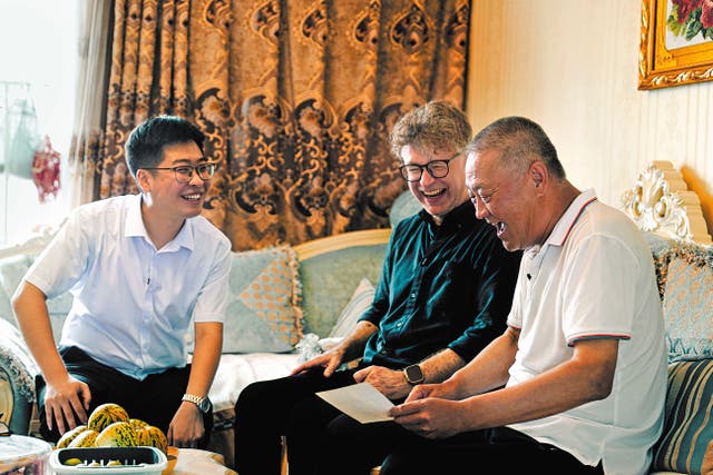 <p>Arthur Jones (middle) and Li Jia (left), an employee of Qinghe Power Plant, at the home of a retired worker of the factory in Tieling, Liaoning province </p>