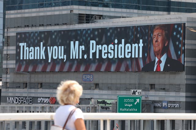 <p>A woman walks past a billboard thanking the US president, Donald Trump, in Tel Aviv, Israel, on Sunday</p>