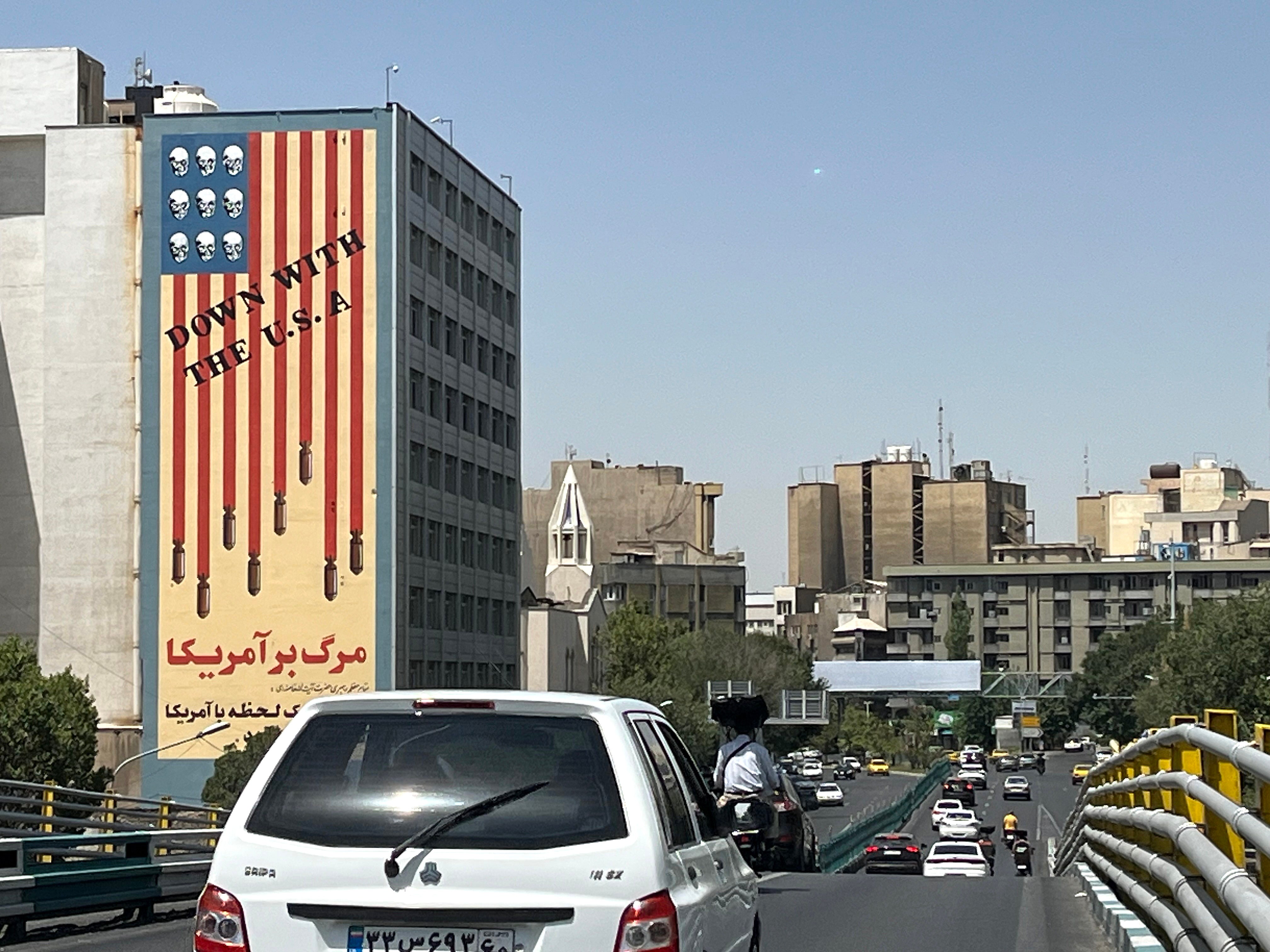 Traffic passes by a building displaying an anti-US mural in Tehran, Iran, 22 June 2025