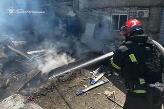 A Ukrainian firefighter extinguishing a blaze following a Russian missile strike in the eastern Ukrainian city of Dnipro