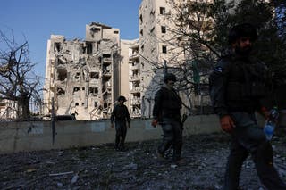Security forces personnel walk past an impacted residential site, following a missile attack from Iran on Israel, amid the Israel-Iran conflict