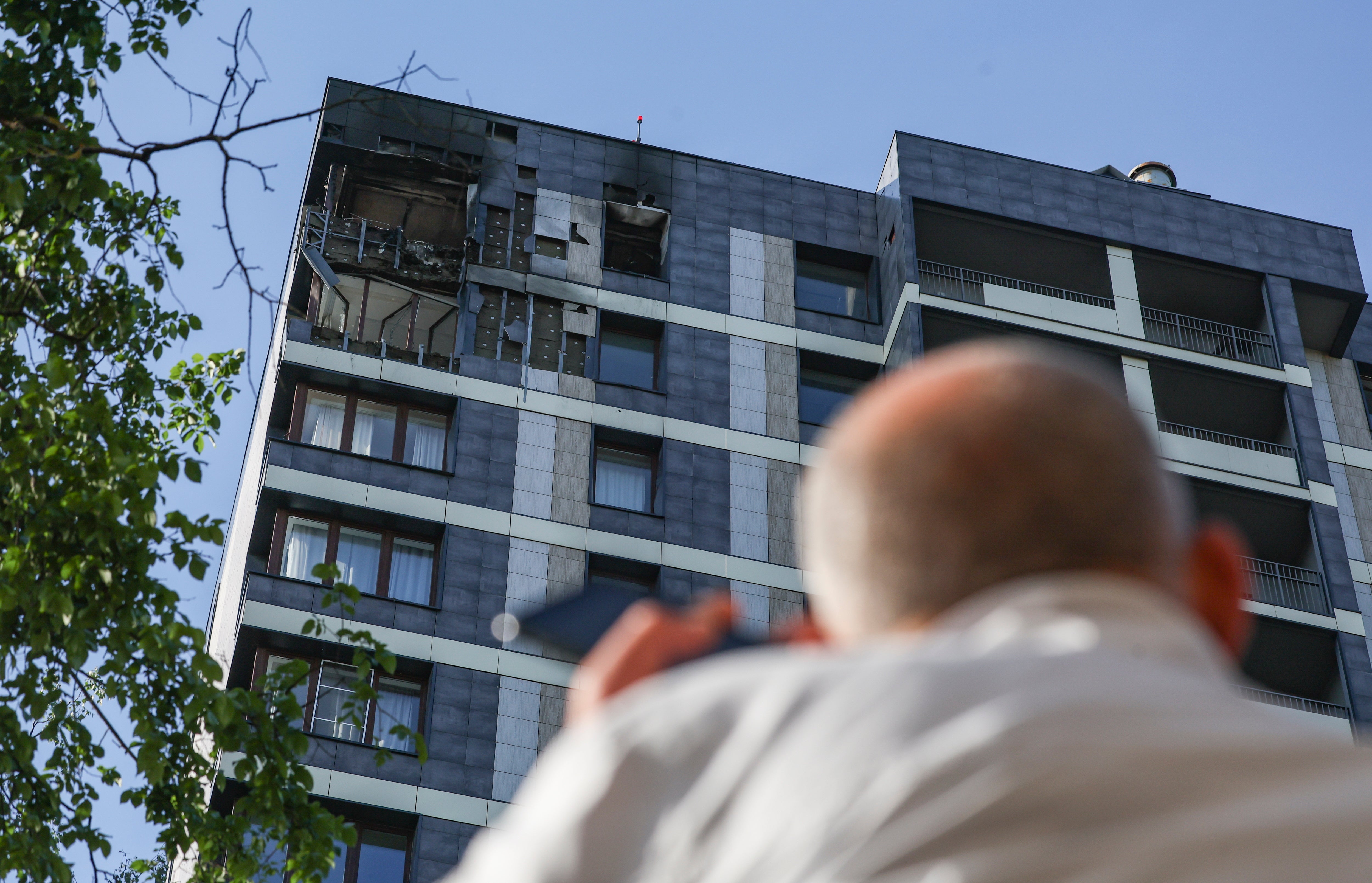 A man looks at a damaged apartment building following a Ukrainian drone attack in Krasnogorsk