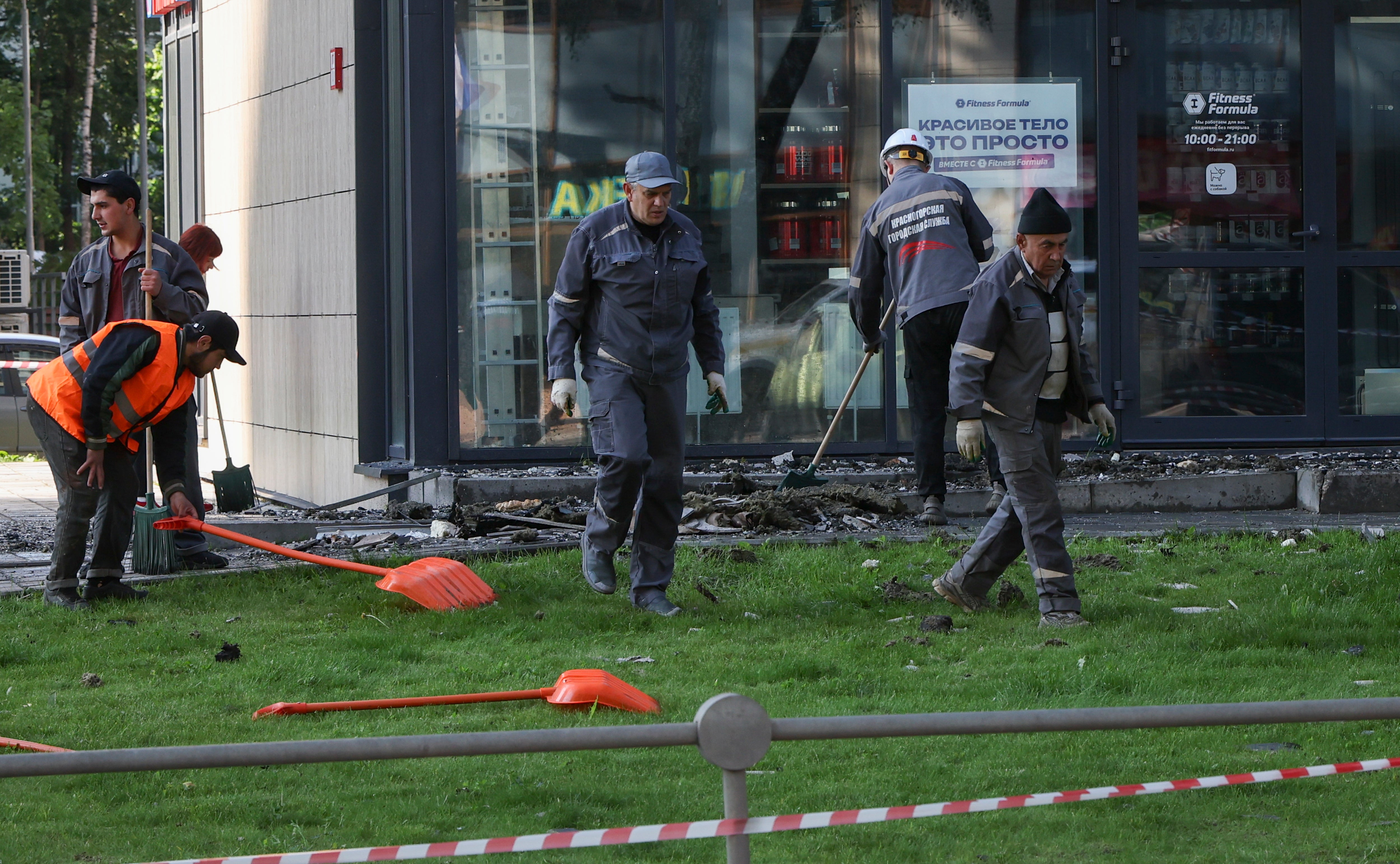 Workers repair a damaged apartment building following a Ukrainian drone attack in Krasnogorsk